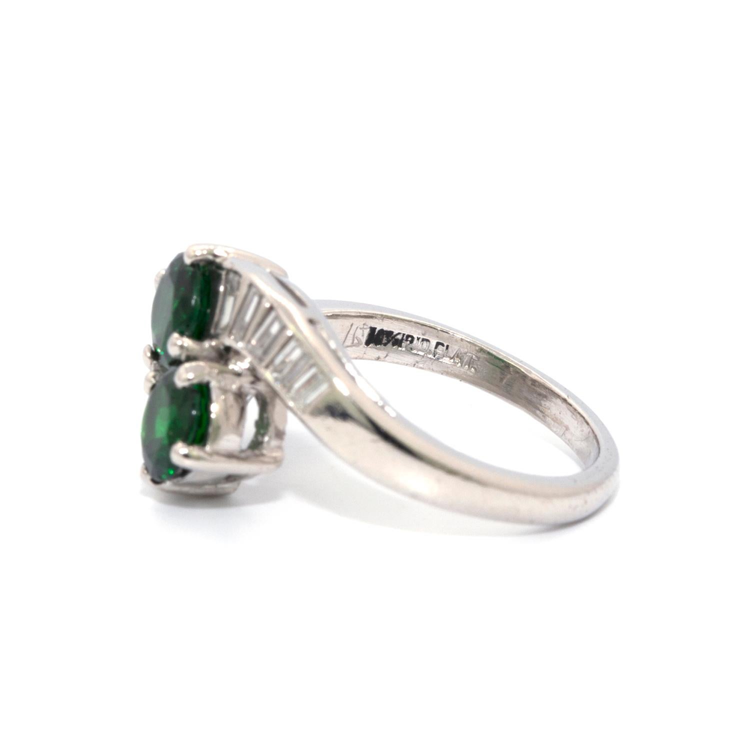 2 matching round Tsavorite Garnets with a total weight of 1.42 cts that are accented by 10 baguette shaped diamonds, that weigh 0.50cts in total and are set in a platinum wrap-a-round Estate ring. Size 5 3/4 Complimentary sizing 
