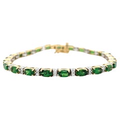 Bracciale tennis con granato tsavorite e diamanti in oro bianco e giallo 14 carati