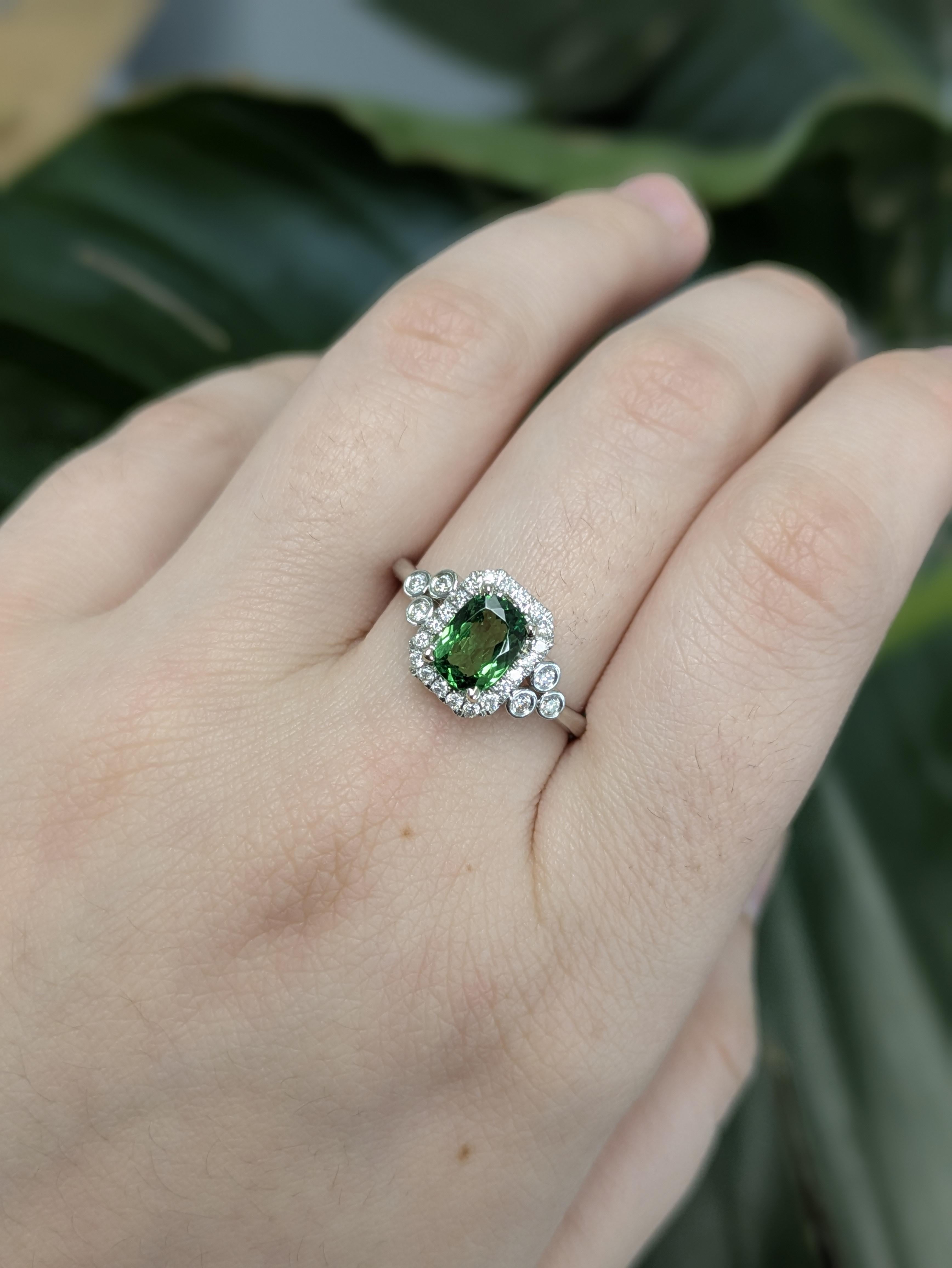 Dieser atemberaubende Ring präsentiert einen leuchtenden 1,00 Karat Tsavorit-Granat im Smaragdschliff (7x5 mm), der aus Afrika stammt und in poliertem 14 Karat massivem Weißgold (2,51 g) gefasst ist. Eingerahmt von 20 funkelnden Diamanten mit