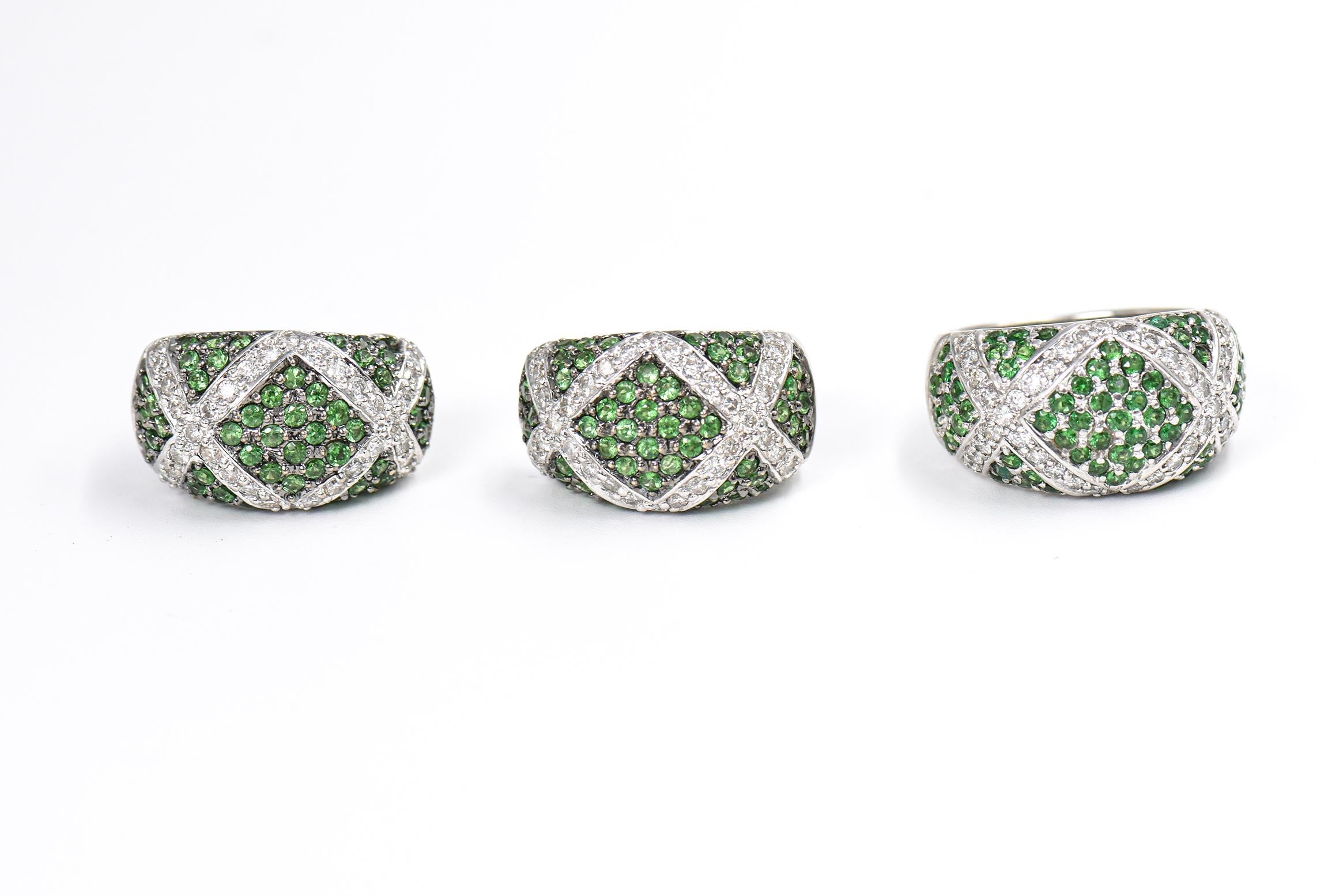18k White gold, diamond and tsavorite garnet dome ring and earrings set.  Each of the band style ring and matching earrings have a criss-cross pattern that features sections of bead set round green tsavorite garnets highlighted by 