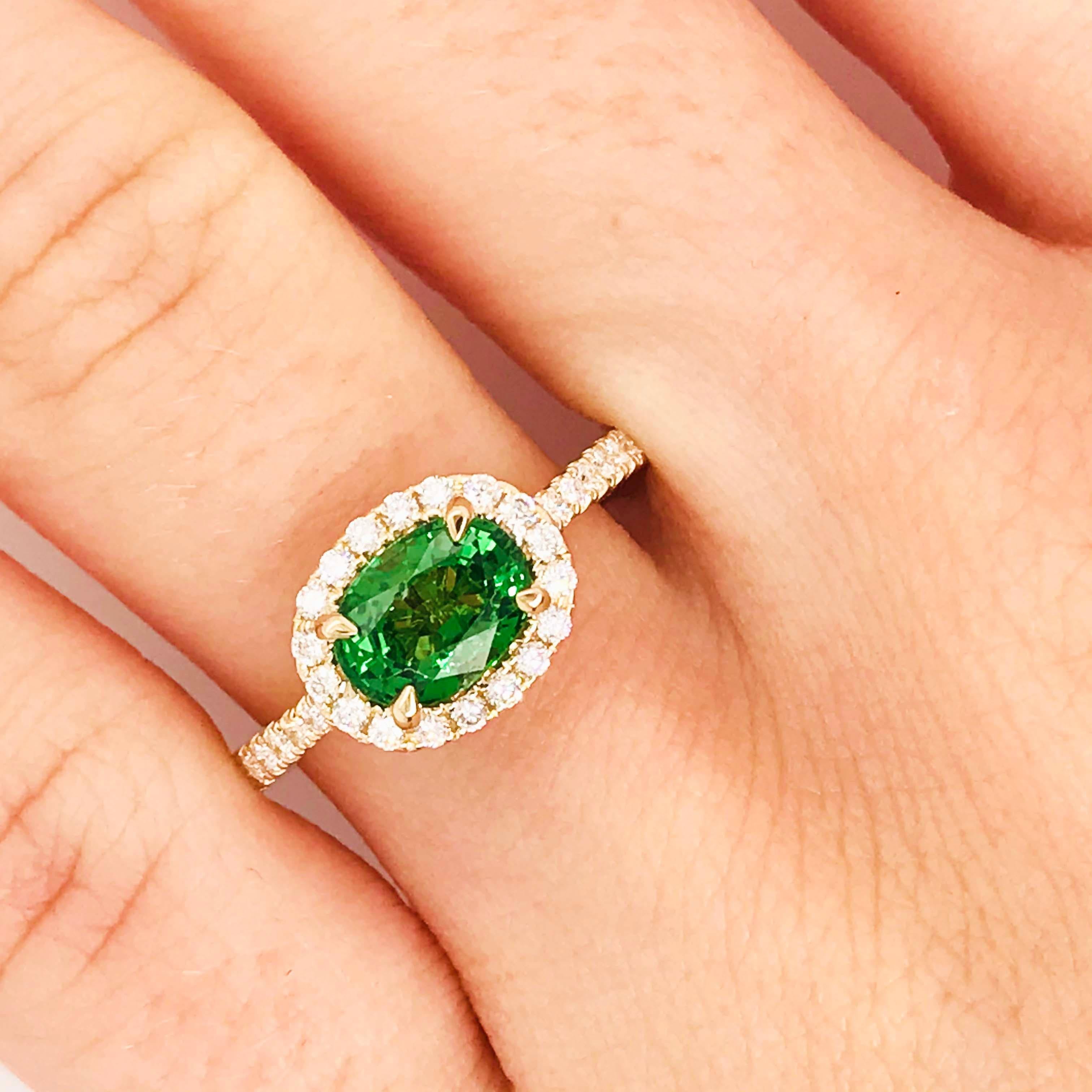 Stunning tsavorite garnet gemstone set in a unique designer setting! This bold ring has a genuine tsavorite garnet gemstone set in four gold, pointed prongs and is framed by a diamond halo. The center setting has bright white, round brilliant
