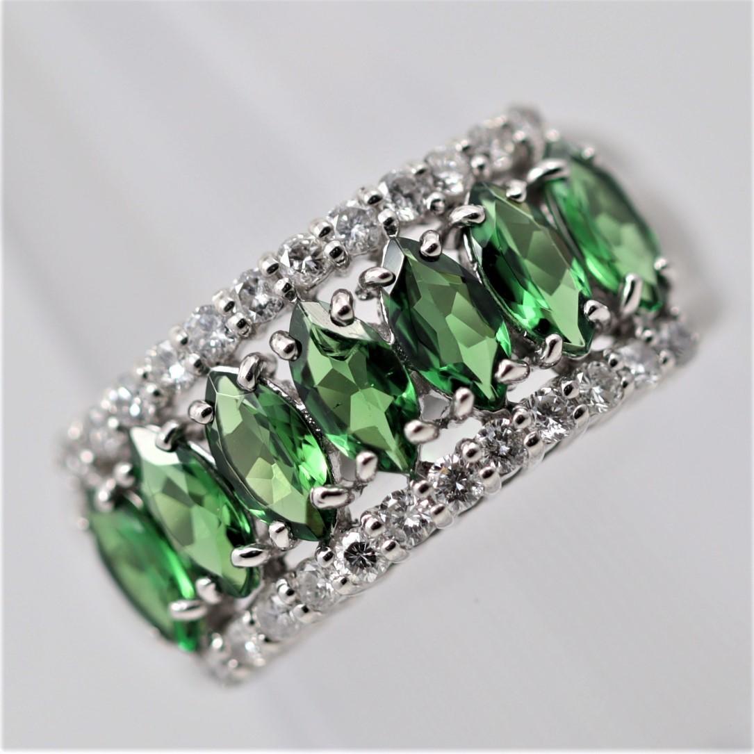 A stylish platinum band featuring 7 marquise-shape tsavorite garnets. They weigh a total of 1.62 carats and are all matching in shape and color, a vibrant grass-green. They are accented by two rows of diamonds set above and below, which weigh a