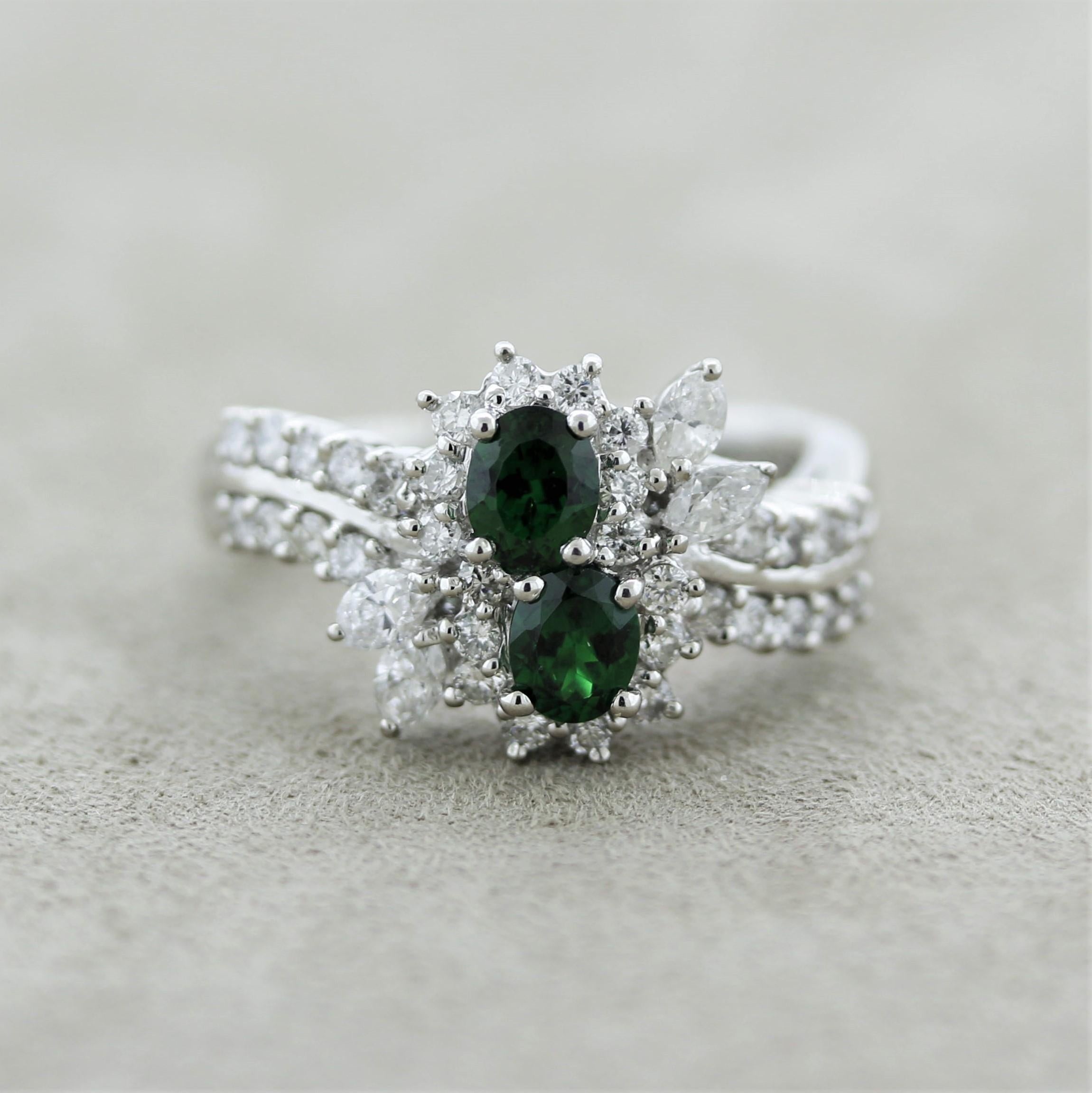 An elegant platinum made ring featuring 2 intense green tsavorites weighing a total of 0.86 carats. Surrounding them are 0.89 carats of round brilliant and marquise-shape diamonds set in a stylish pattern. Hand-fabricated in platinum and ready to be