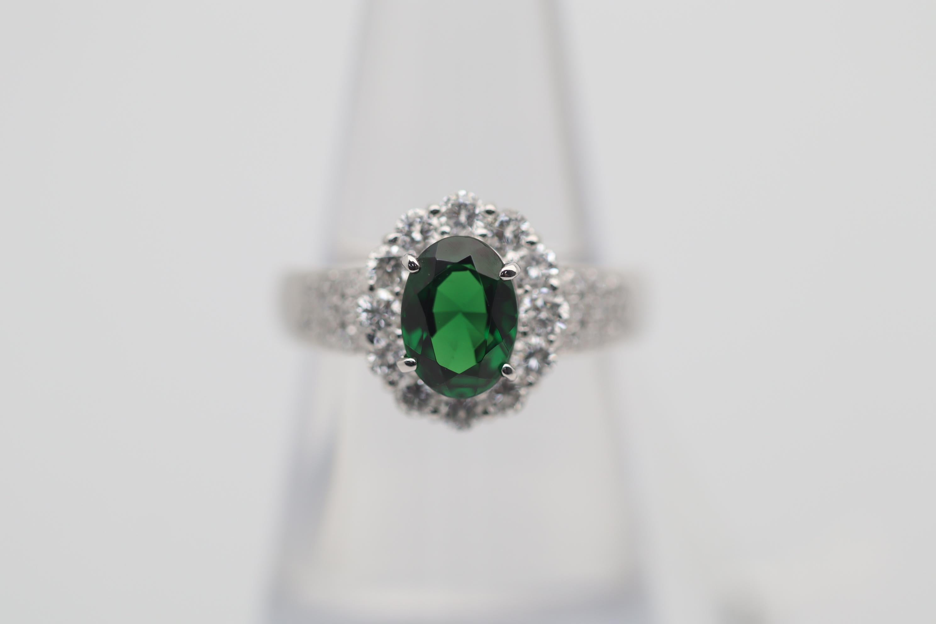 A fine richly saturated tsavorite takes center stage of this platinum ring. It weighs 1.61 carats and has a rich intense green color unique to tsavorites. It is complemented by 0.79 carats of round brilliant-cut diamonds set around the ring adding