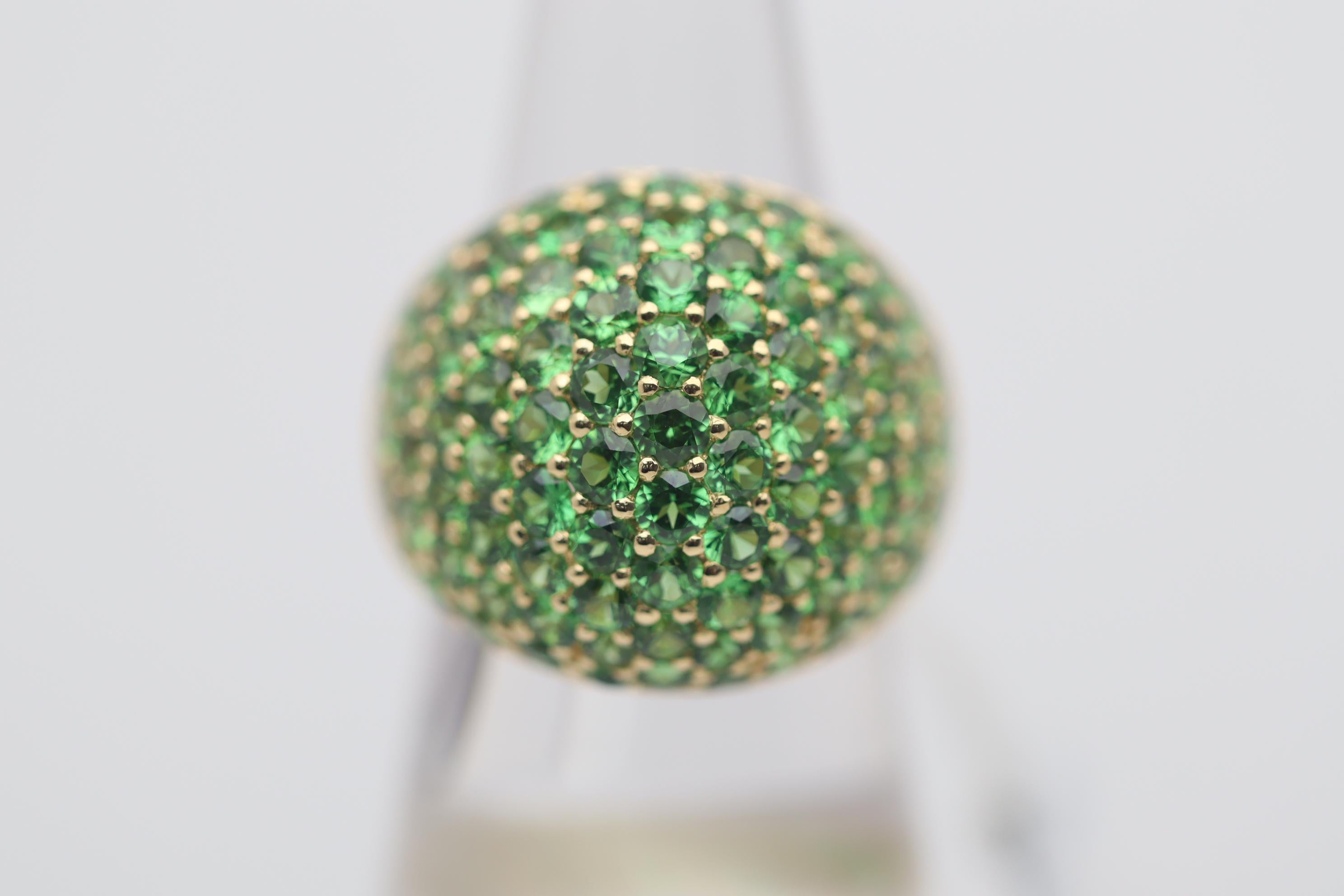 A well-sized dome style bombe ring featuring 8.09 carats of tsavorite garnets. They are pave-set around the ring and have an intense bright green color. Made in 18k yellow gold and ready to be worn.

Ring Size 7.50

Weight: 13.7 grams