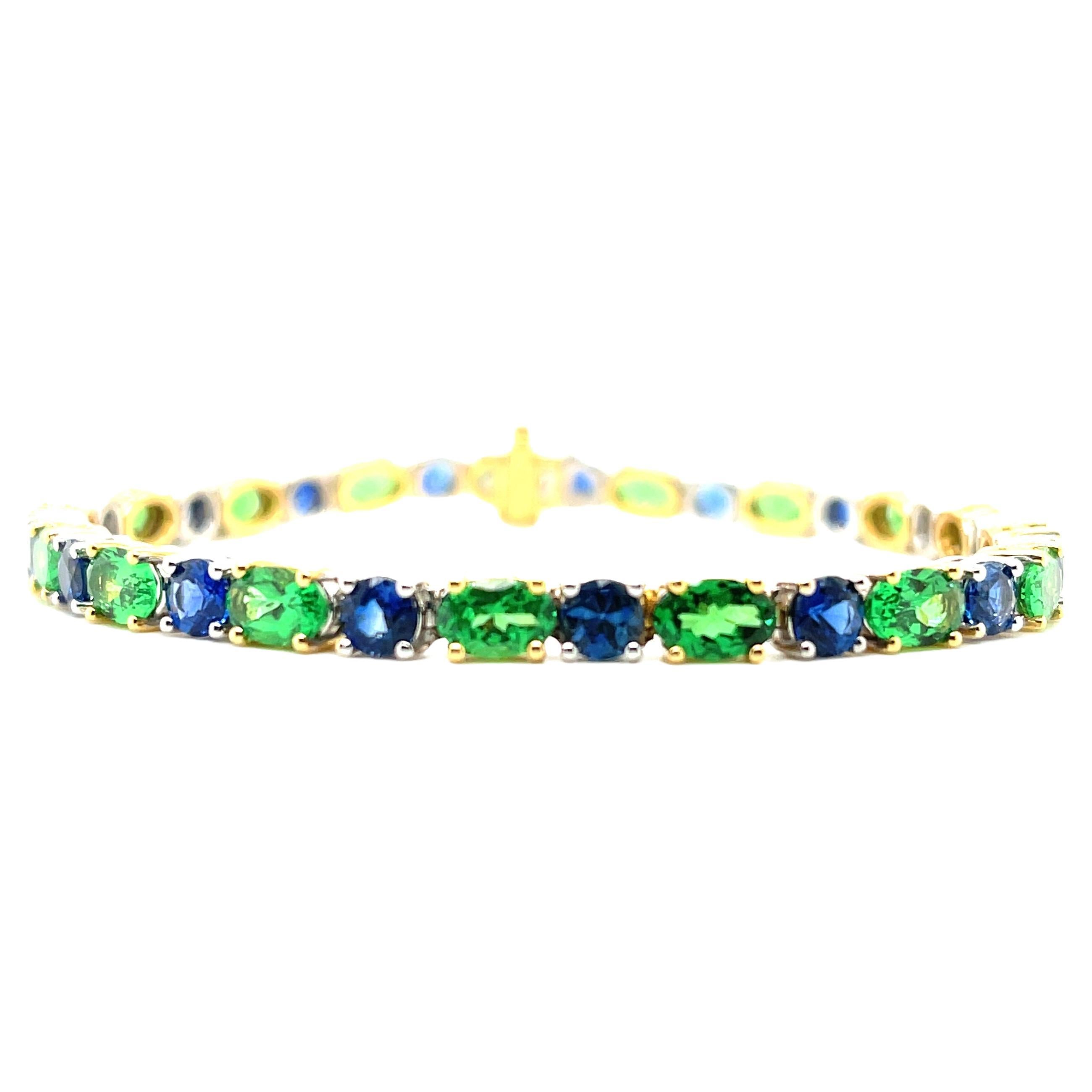 This stunning tennis style link bracelet features a sparkling collection of top quality blue sapphires and tsavorite green garnets set in 18k white and yellow gold! The blue sapphires are diamond cut for maximum brilliance and 