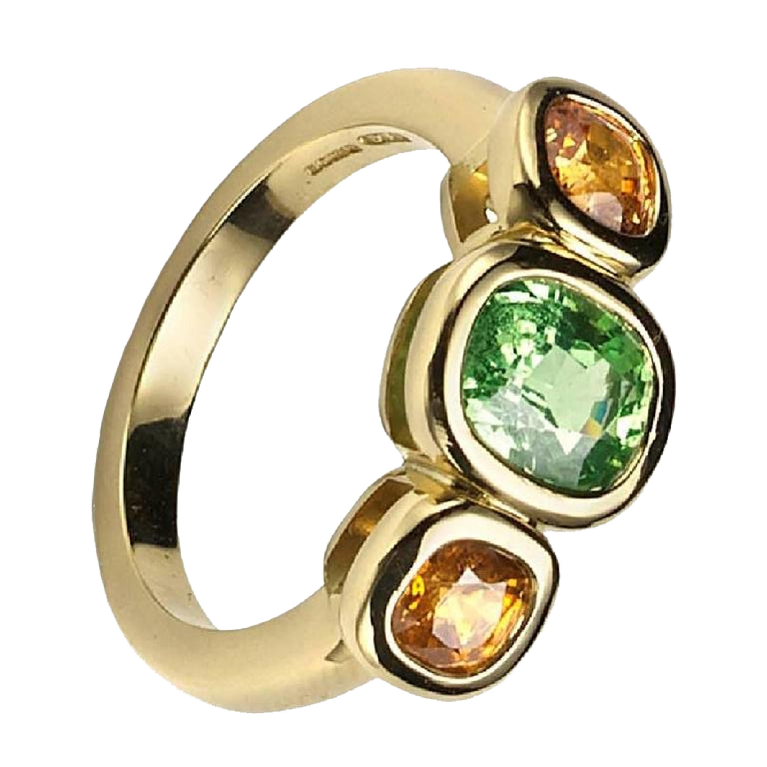 Yellow gold 18kt three stone ring set with Tsavorite and two Mandarin Garnets.
Ring size:  M
Stones:  tsavorite 7.04 x 5.3 mm, garnets 4.27mm diameter