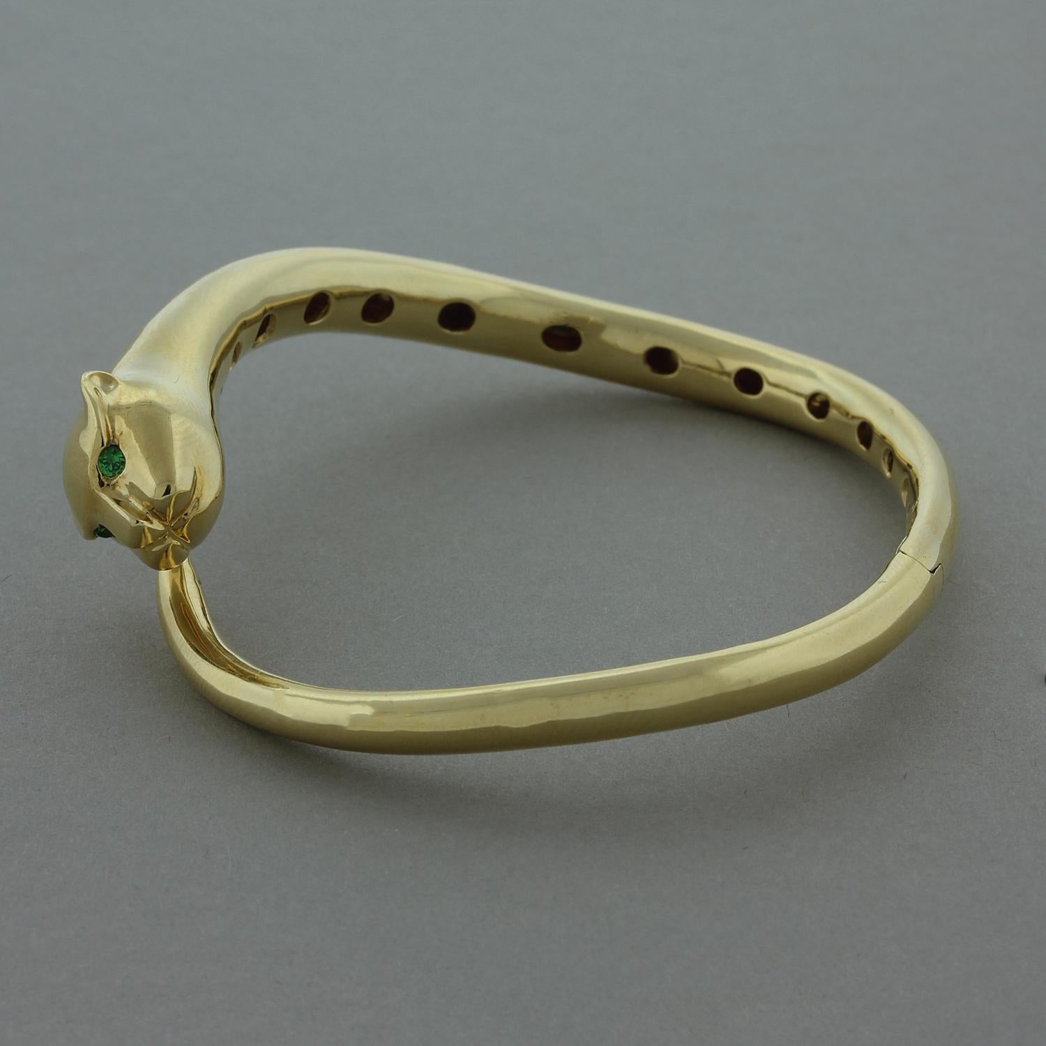 A royal panther cuff with round cut tsavorite for piercing eyes. This 18K yellow gold cuff has a hidden and comfortable opening with easy closure for this sleek bracelet.

Bracelet Length: 6.75
Weight: 25.00 grams
