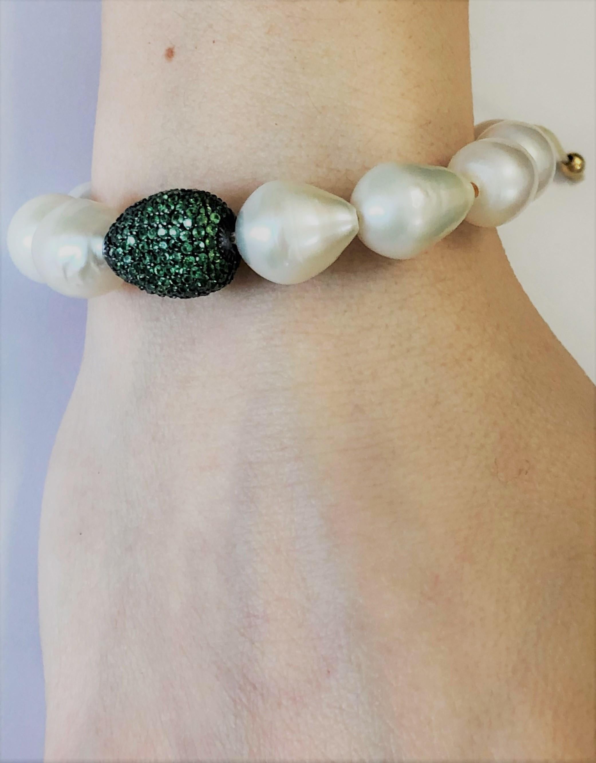 Nice bracelet made up of  tsavorite pave on silver setting, baroque white pearls and macrame clasp. 
Tsavorite pave ct. 3,40
Baroque white pearls
macrame clasp system
Total diameter cm 6,5 - it fits well for a medium wrist ( about 14-15 cm) 