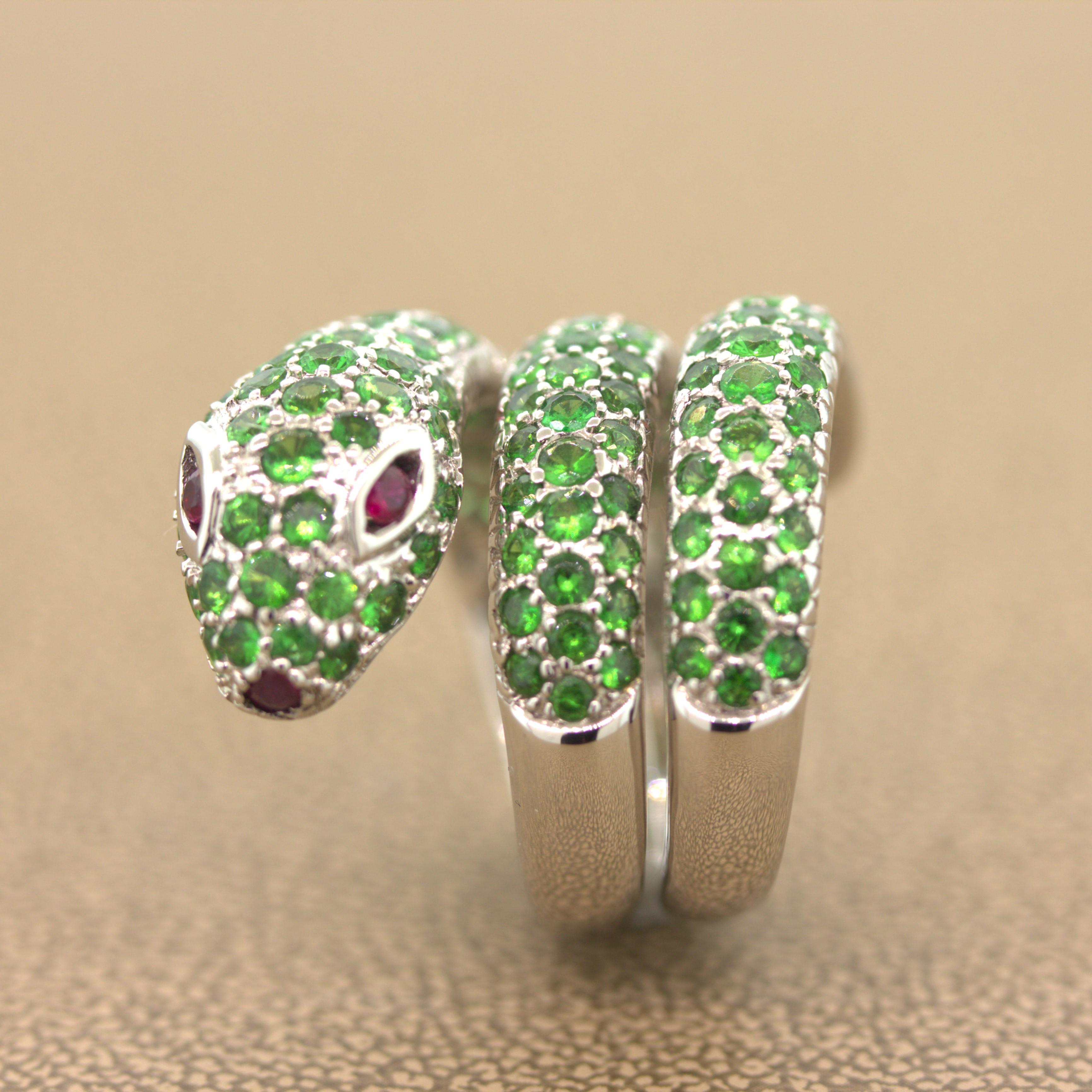 A sleek and sexy snake blanketed with 3.90 carats of bright green tsavorite garnets. The snake wraps around the finger 3 times for a chic look. Its eyes and mouth are set with vivid red rubies giving it a sharp gaze. Made in 18k white gold, this