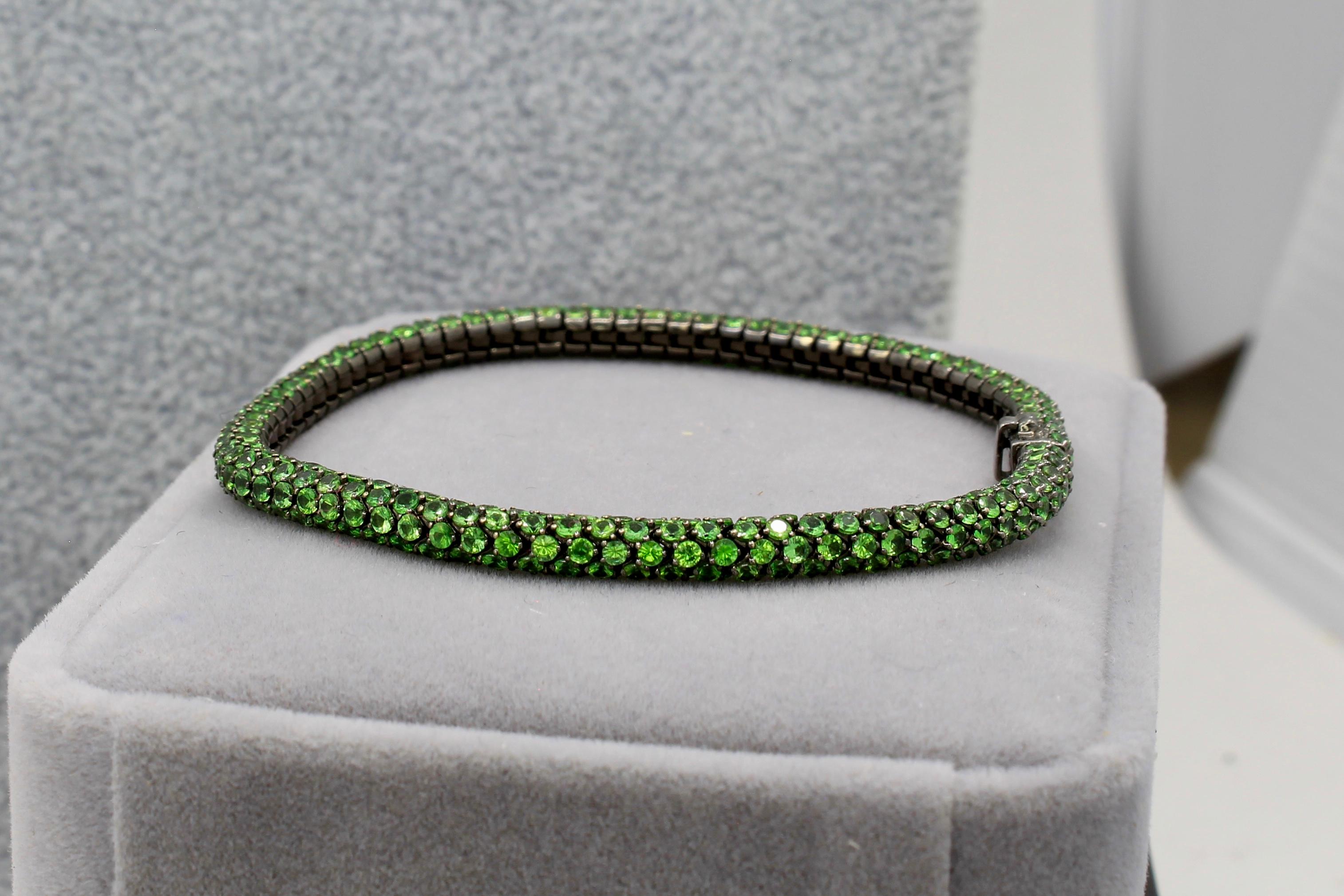 Why not have sparkle in every direction on your tennis bracelet? Well this tennis bracelet has 5 Tsavorites per row. The bracelet is made with 18K blackened gold which uses black rhodium plating on white gold. It weights over 16 grams and is set
