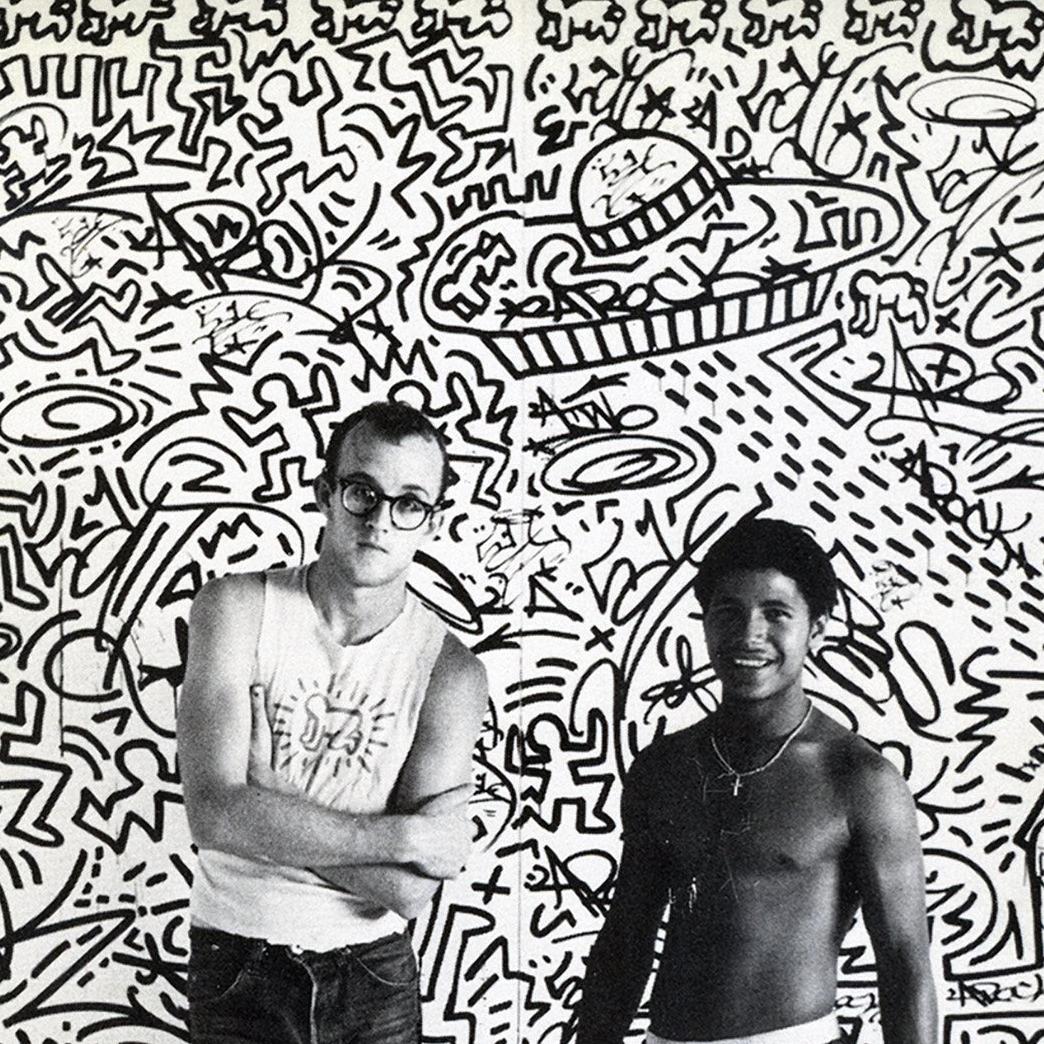 Keith Haring with LA2:
Rare original 1982 announcement card for an early exhibition of Keith Haring’s work at Tony Shafrazi Gallery, New York, October 9 – November 13, 1982.  The front of the card features a photograph of Haring with longtime friend