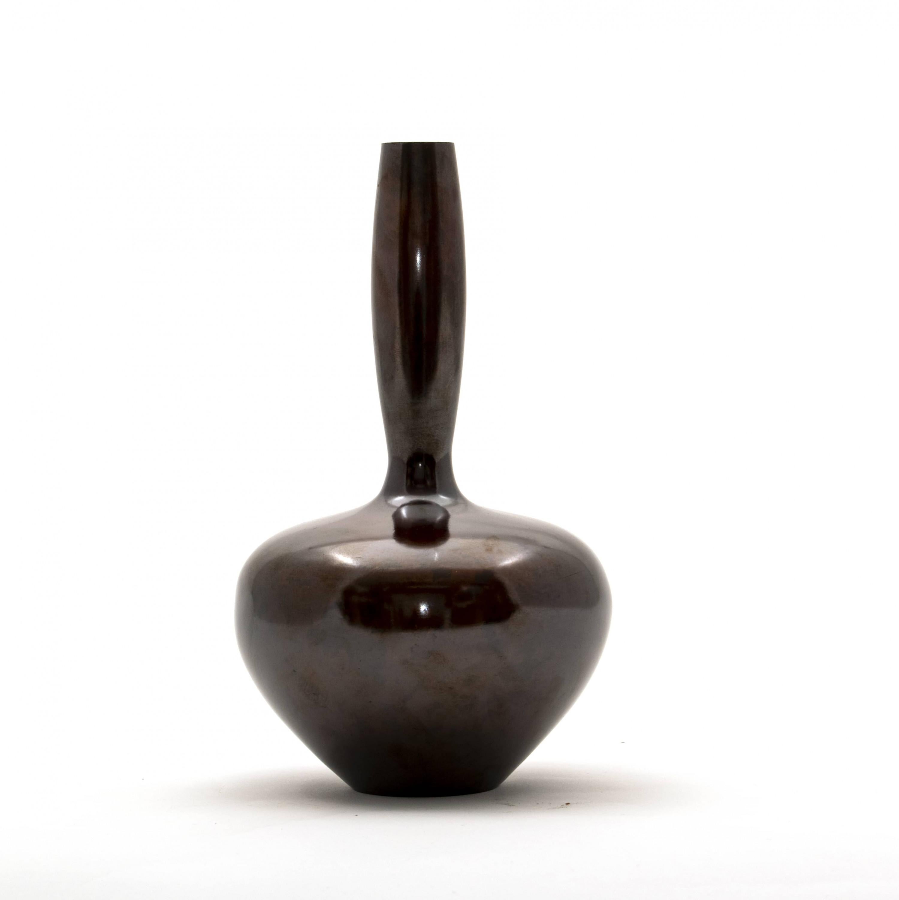 Tsuda Eijyu (1915-2000).
A Japanese patinated bronze vase of globular form with a long and narrow neck. Seal marked.
Vases like this one is used to decorate single flower arrangement in Japanese traditional tea ceremony.

Tsuda Eijyu (1915-2000)