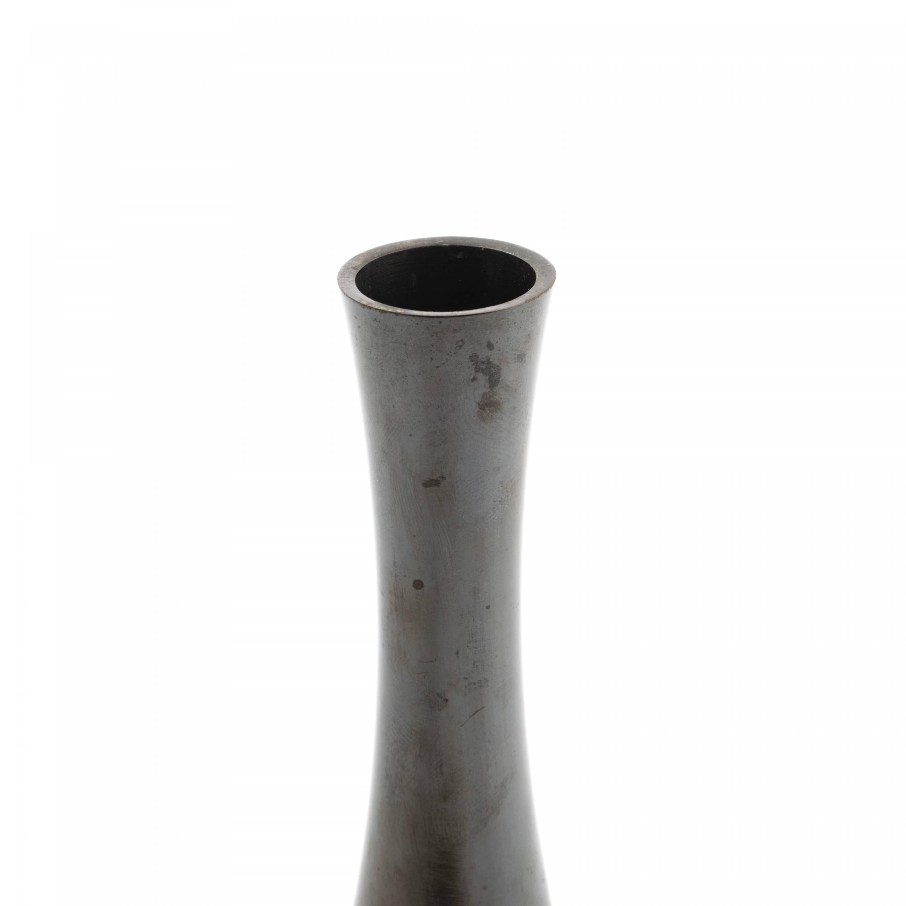 Tsuda Eijyu (1915-2000).
Japanese vase in patinated bronze.
Half-globe shape with long neck.
Seal marked in the bottom.
Weight 930 g. H. 20 cm.

With original wooden box.