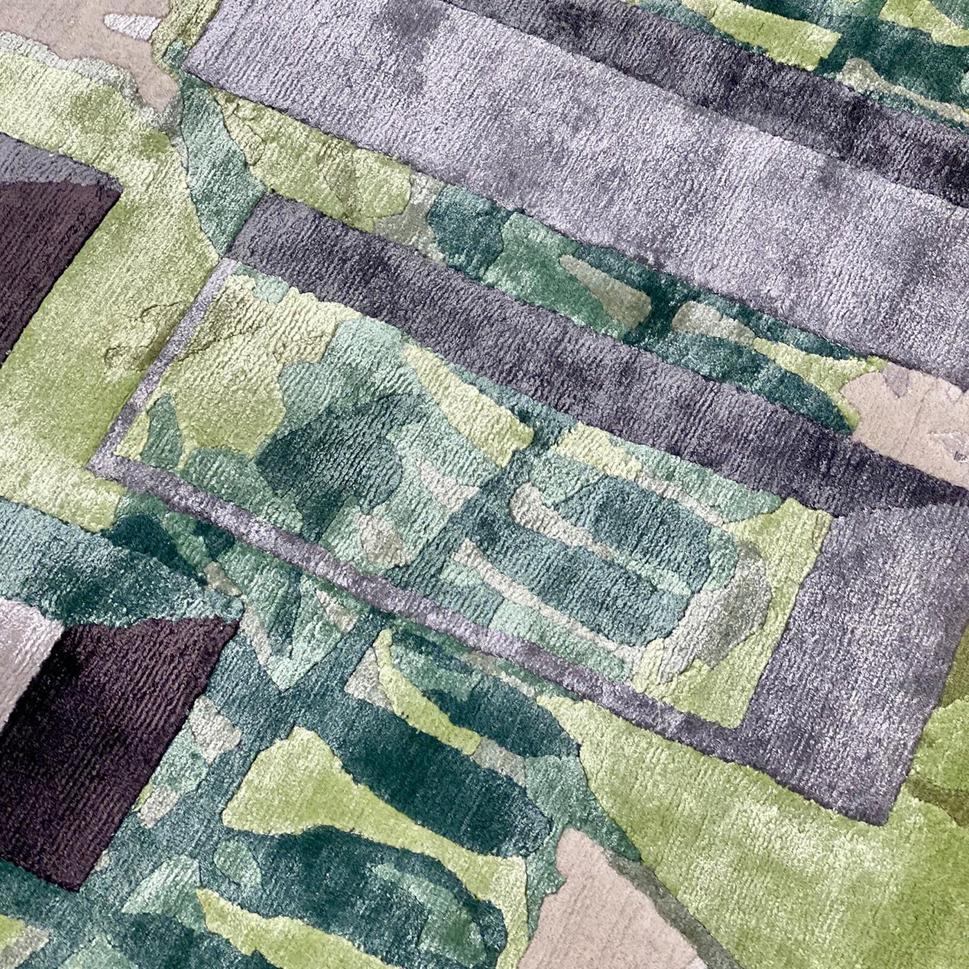Des feuillages dans différentes nuances de fils verts adoucissent la rigueur du fond dans ce splendide tapis (base H .05 cm et motif H .07cm). Noué à la main au Népal, composé de 50 % de soie et de 50 % de laine de l'Himalaya, avec 152 000 nœuds/m²,