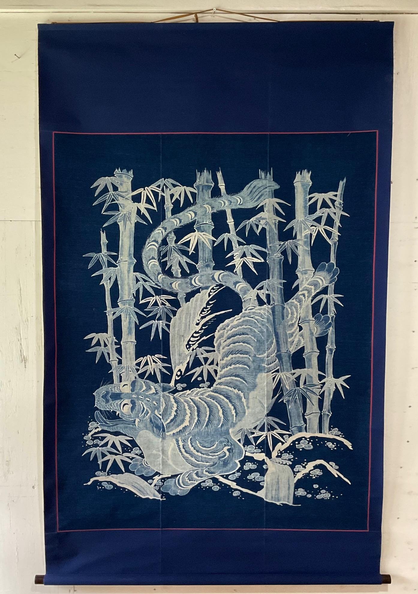 This tsutsugaki cotton textile is a phenomenal piece of Japanese history, having served as a luxurious futon cover in the 19th century. The piece features a majestic tiger, poised and powerful, amidst a serene bamboo forest—a subject rich in
