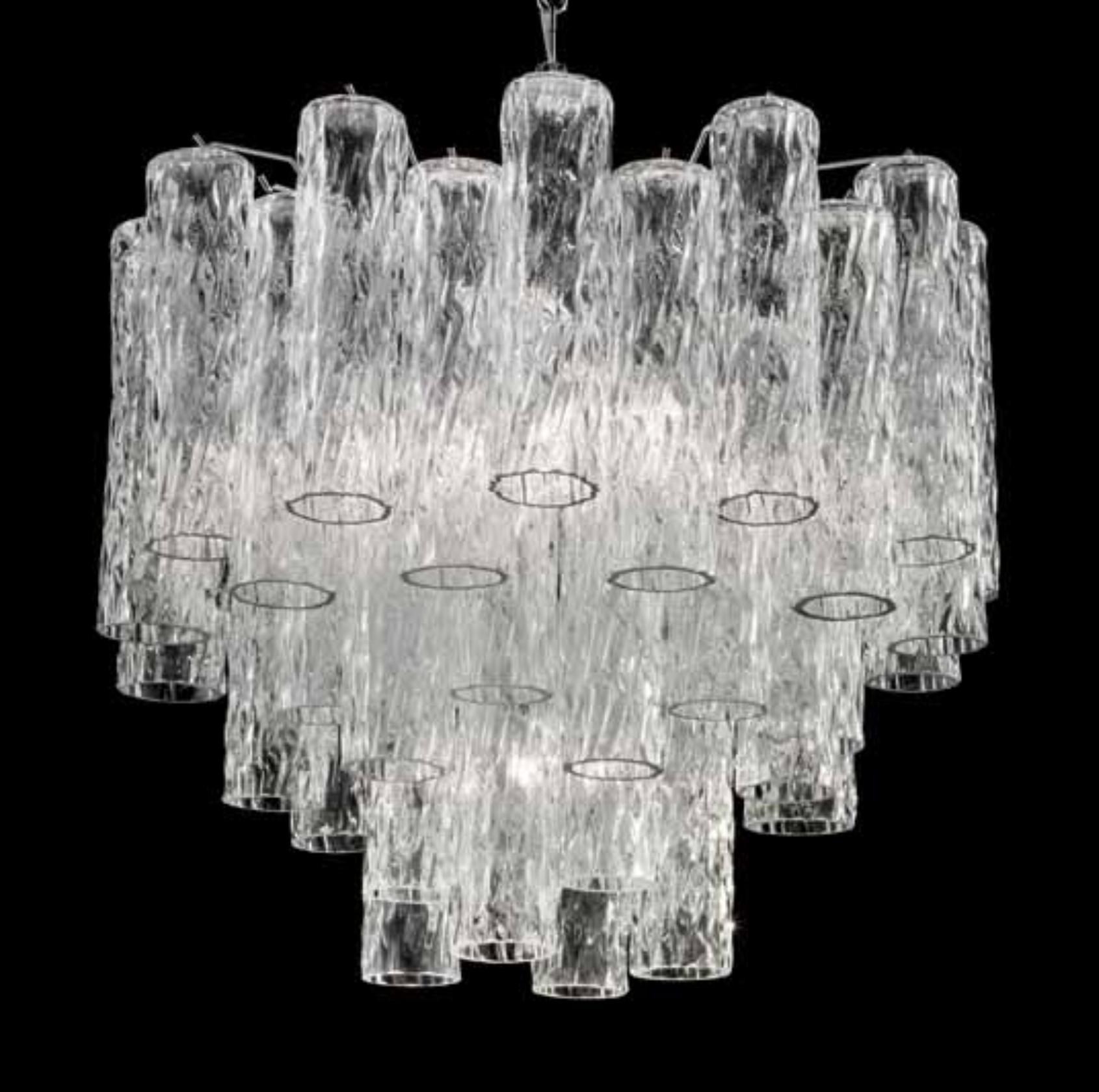 Lampadario italiano con tubi in vetro di Murano chiaro e testurizzato disposti su più livelli, montati su una struttura in metallo con finitura cromata / Made in Italy
6 luci, tipo E26 o E27, max 60W ciascuna e 1 luce, tipo E12 o E14, max