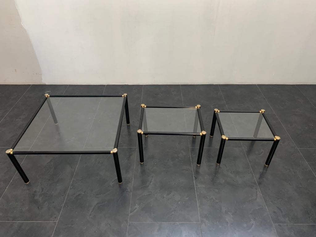 Set of 3 coffee tables 60's in metal tubular of generous thickness. glossy black lacquered brass fittings 
Large H38X82X82
Medium H38X56X41
Small H33X46X41

Packaging with bubble wrap and cardboard boxes is included. If the wooden packaging is