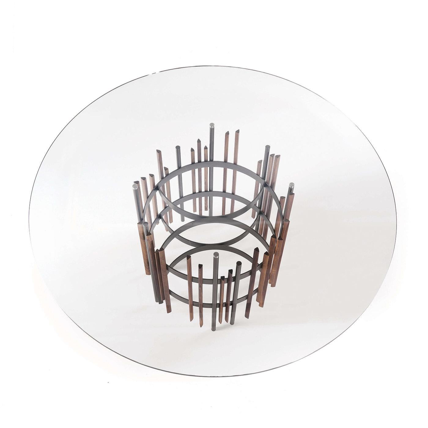 This stunning dining table is part of the Tube collection designed by Norberto Delfinetti. Its structure in titanium-painted metal is made up of a multitude of vertical elements with details in solid Canaletto walnut. This sculptural piece is