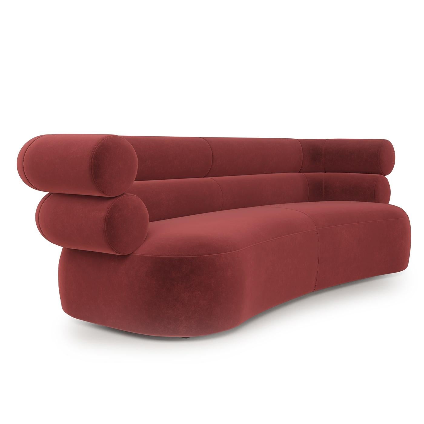 A sumptuous piece sure to make a statement in modern living spaces, this sofa flaunts a ruby-red polyester velvet upholstery wrapped around a series of plump, geometric-inspired volumes. A rich polyurethane foam padding complements the plywood