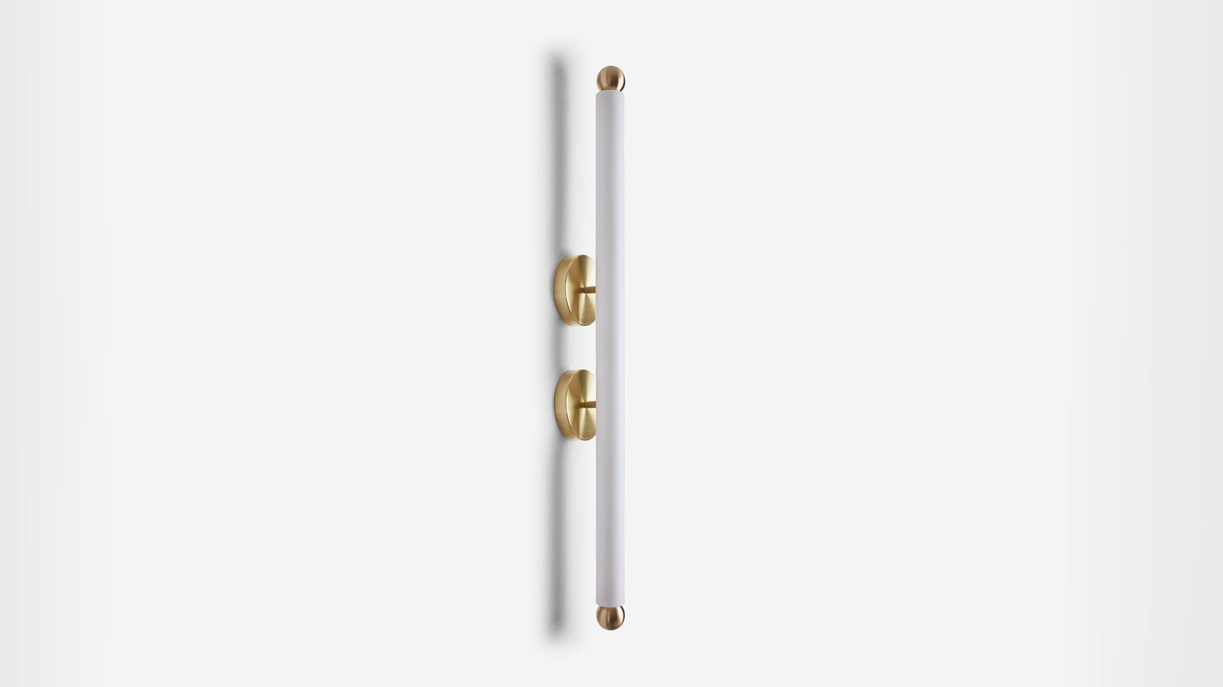 TUBE SCONCE XL Twin spun metal backplates anchor and elevate the bright light of the TUBE collection. With an extended matte blown-glass cylinder this graphic combination of light and hardware adds a bright and percussive rhythm to any space. UL,