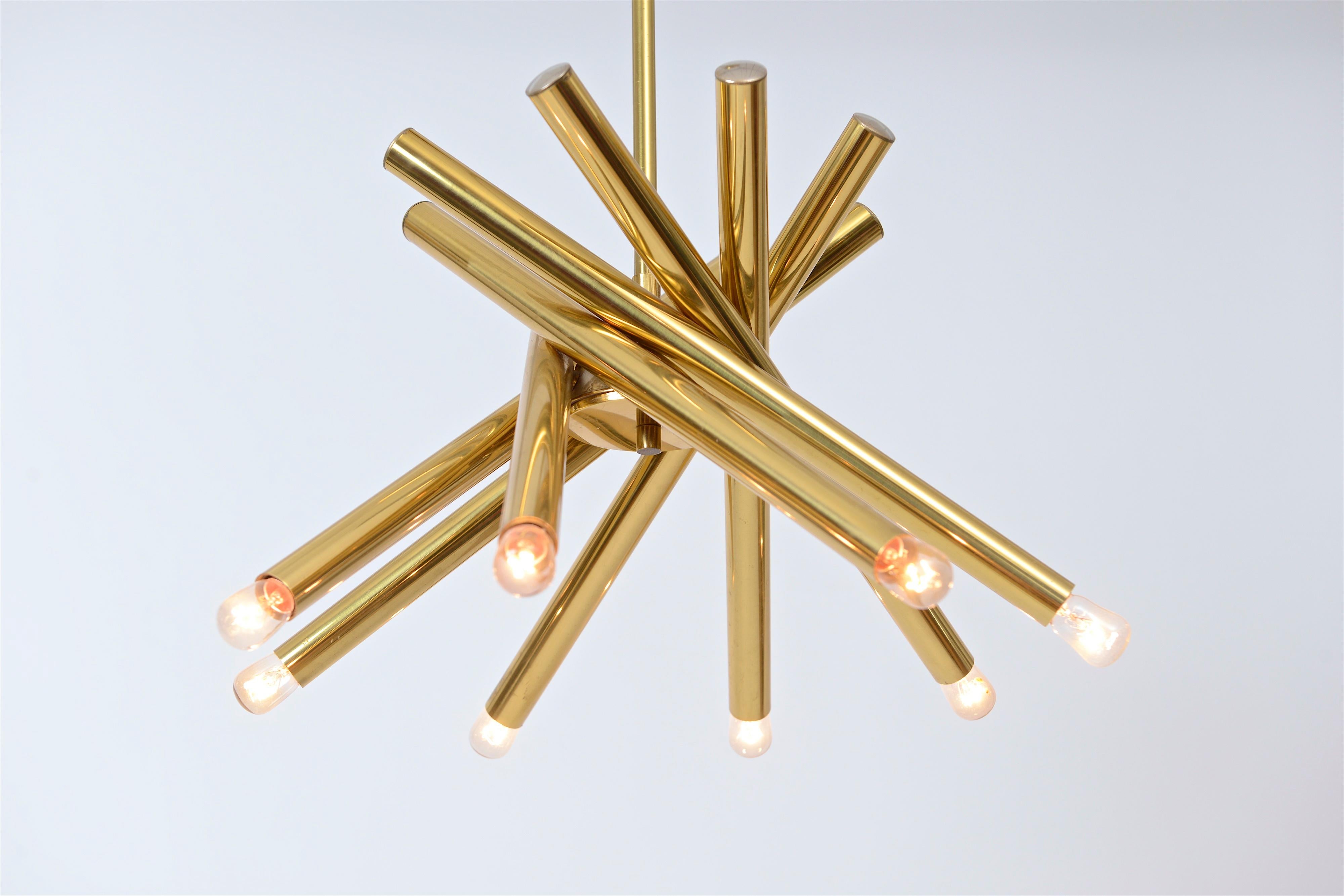 Un lustre tubulaire en spirale à huit lumières à la manière de Gaetano Sciolari, vers 1970. Les bras en laiton laqué sont suspendus à une tige centrale en laiton, ce qui crée un effet visuel très frappant.