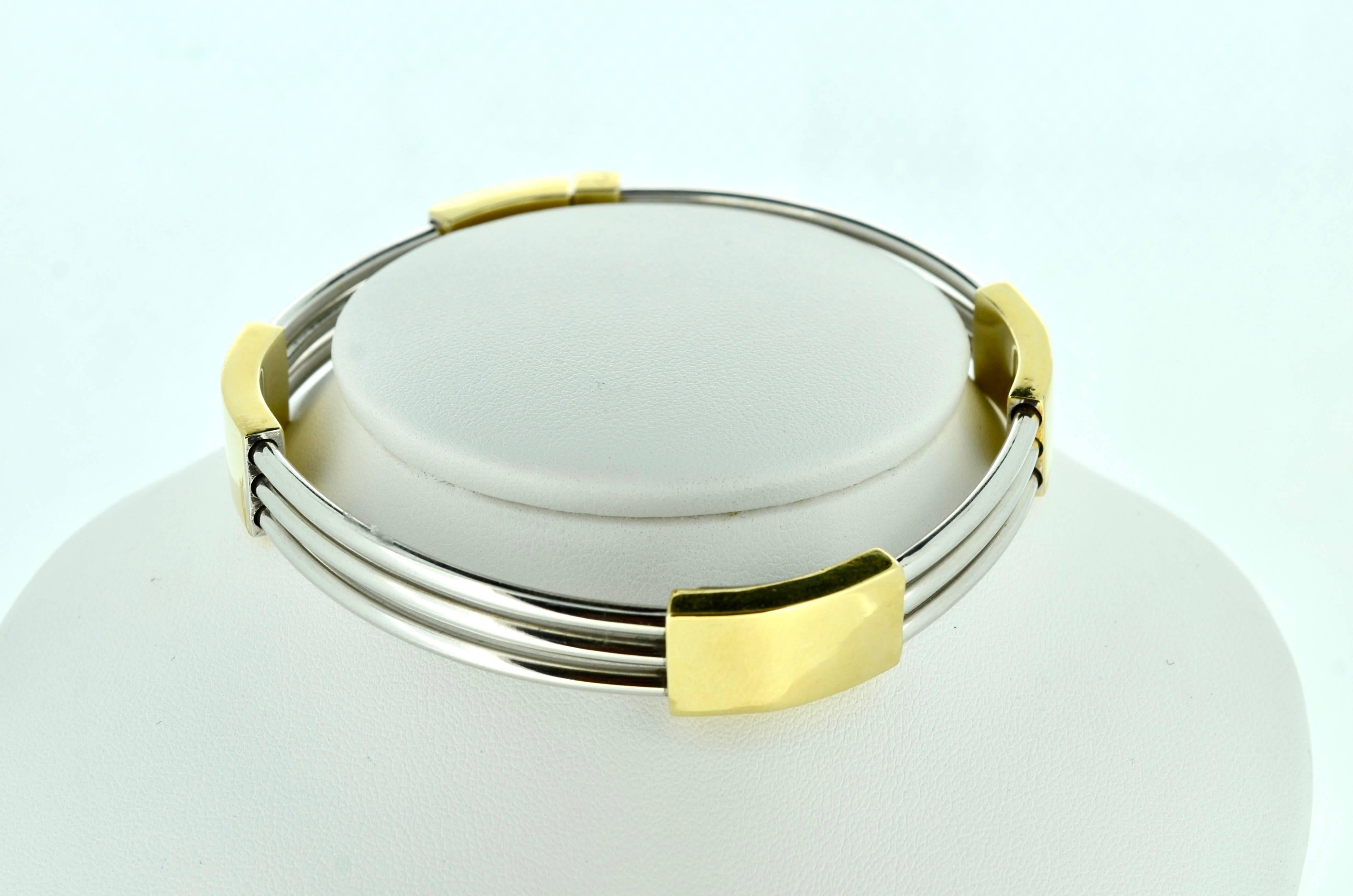 Contemporary bracelet in 14kt white gold and yellow gold. Open triple tubular bars intersecting with contrasting 14kt yellow gold rectangular bars. Inside diameter is 8 inches. 11.5mm uniform width with plunger clasp.