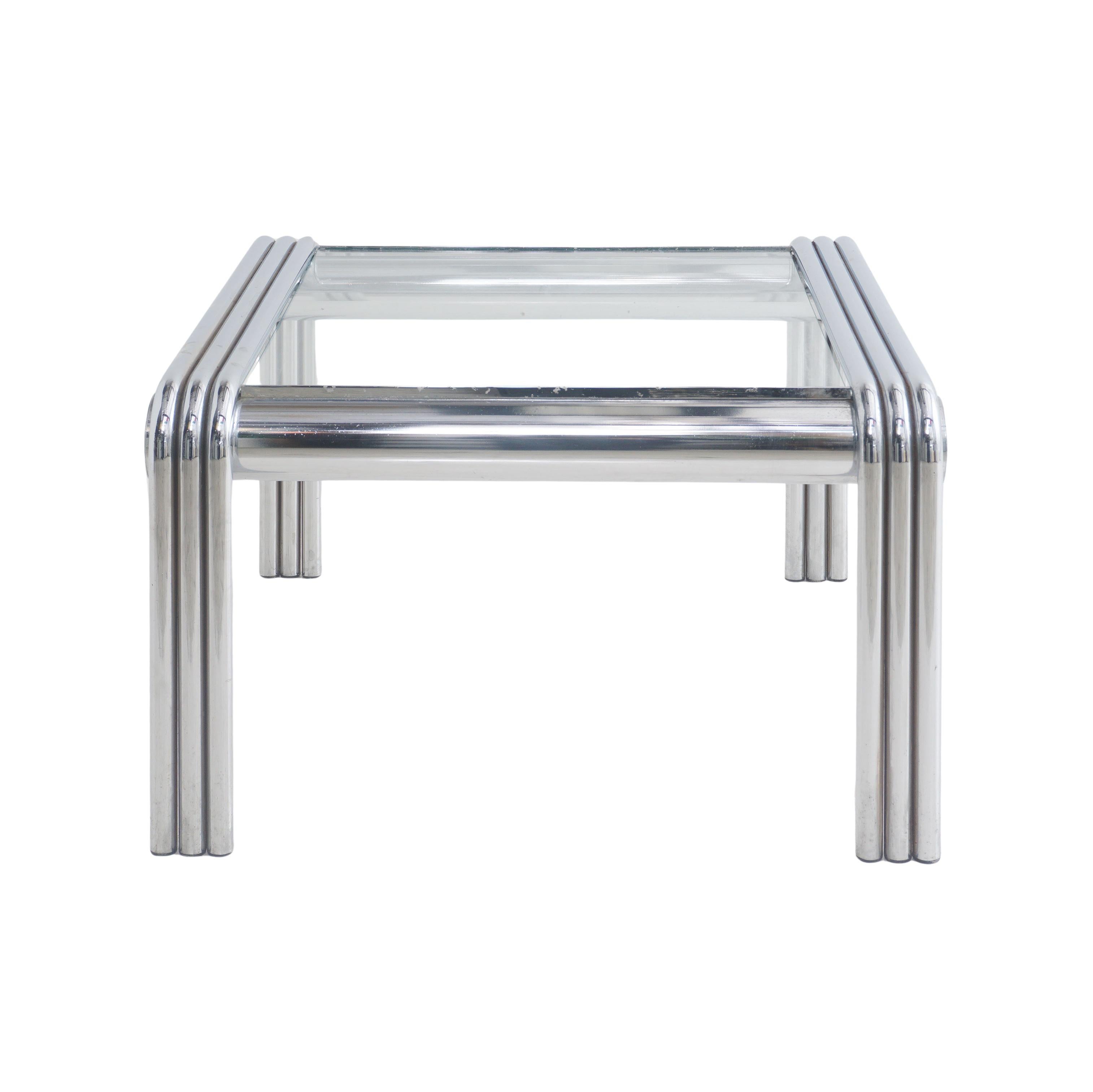 Behold, the tubular chrome and glass side table from the tumultuous 1970s! With its chrome legs like the limbs of a mechanical insect, it stands as a testament to the era's fusion of art and technology. The glass top, a fragile portal to another