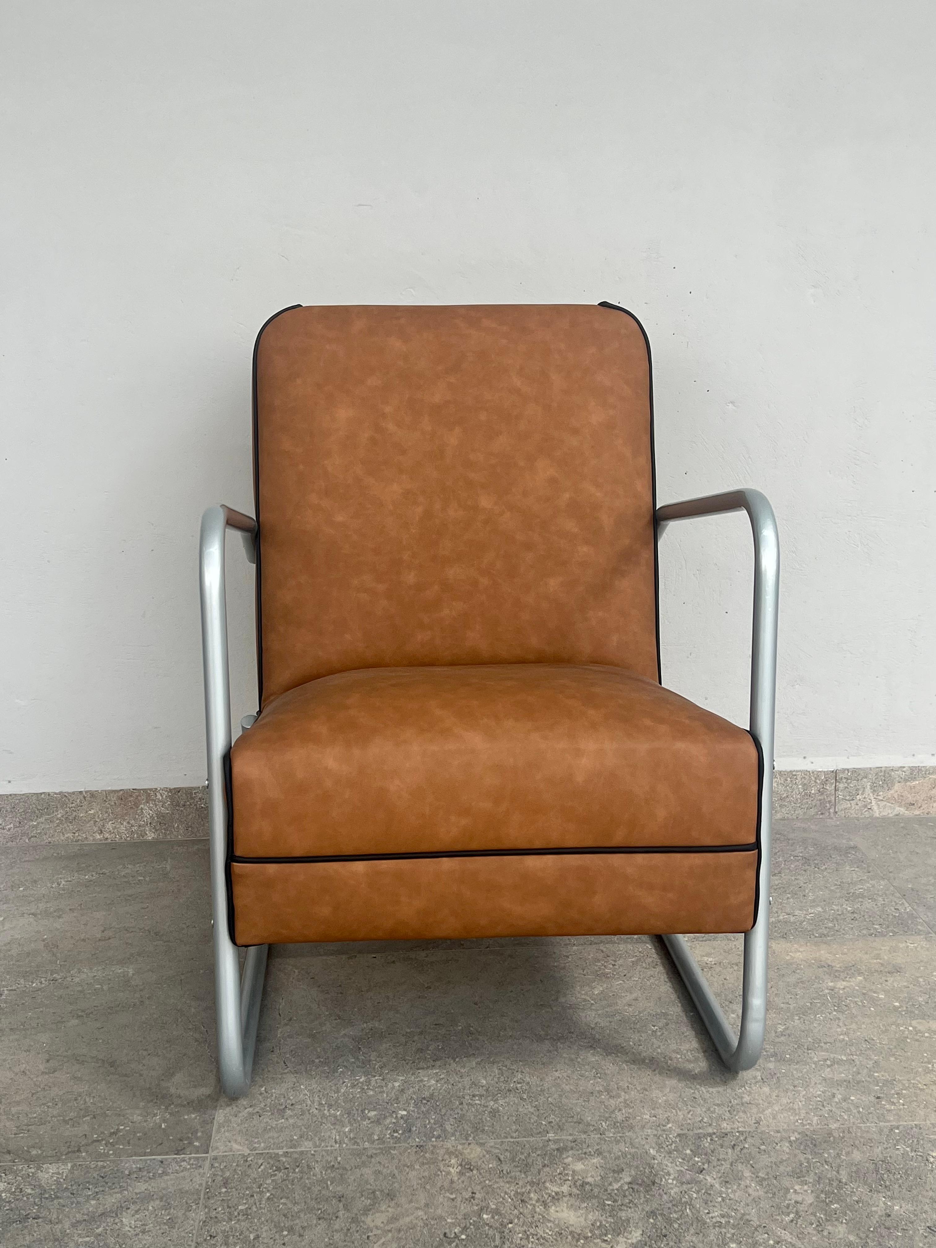 Bauhaus style armchair, reupholstered in imitation leather fabric with contrasting piping, the metal was chrome plated but we decided to paint it with electrostatic paint, comfort and design in this piece