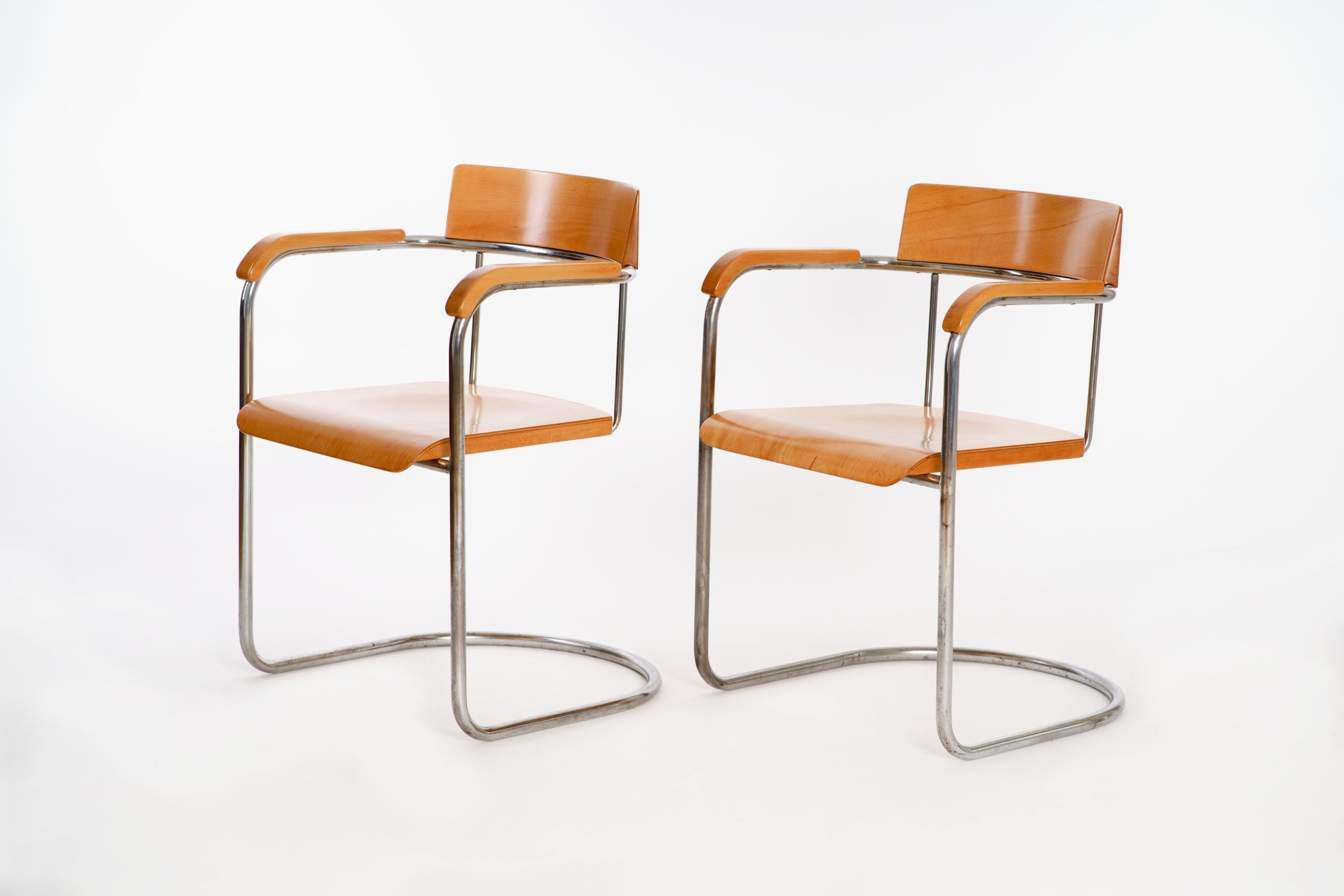 These 2 tubular steel chairs were made in 1930 by Vichr in the former Czechoslovakia. The chrome-plated steel tube has been polished and is in a good original condition with patina, the wooden parts have been restored.