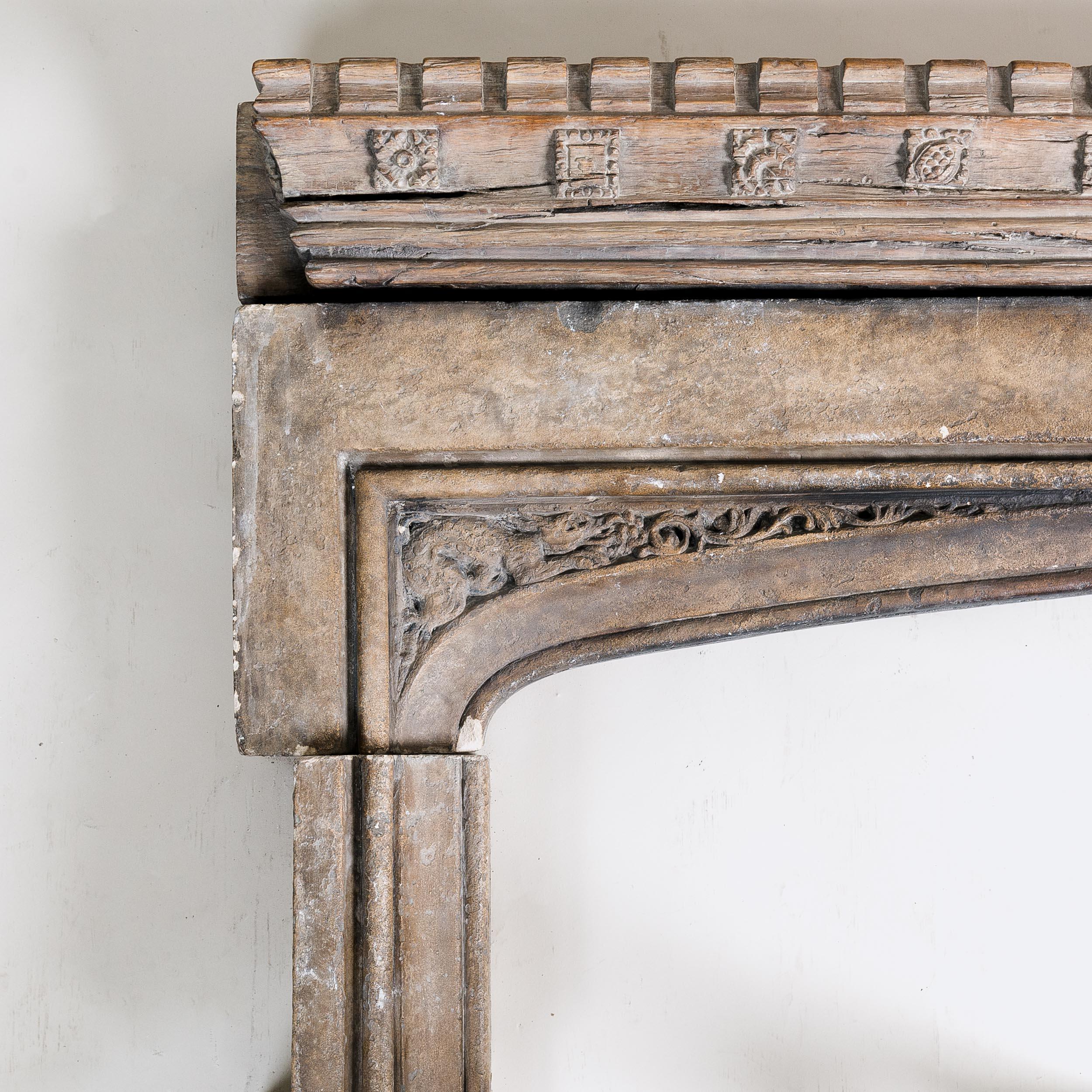 A Tudor arched stone recessed fireplace, removed from the 25 Brook Street, Mayfair, currently the 'Handel & Hendrix' museum, installed by Charles J. Duveen in the early twentieth century. 

With single beam crenellated oak lintel with carved