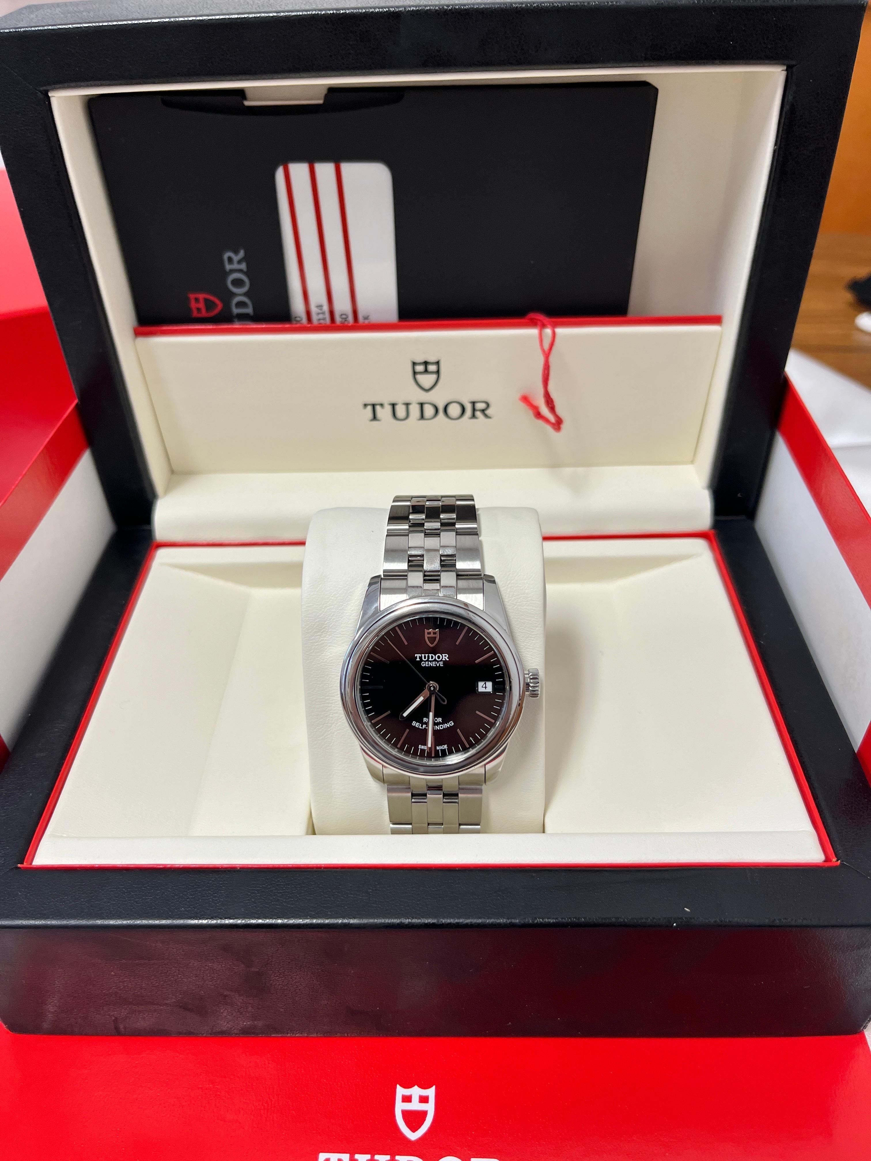 Tudor Glamour Date 55000 with all original parts, box, card, pamphlet papers, tags, and fully linked. A full set. 

36mm stainless steel men's timepiece boasting a captivating black dial, smooth double bezel, and an integrated bracelet that hugs the