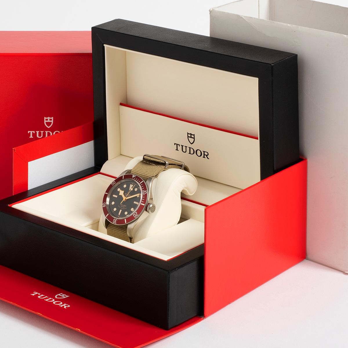 Our collectible Tudor Heritage Black Bay reference 79220R with 41mm stainless steel case, red bezel and gold tone writing and indices is one of the earlier Black bays, with 'smiling dial' , Tudor rose and rose crown as well as ETA movement. This