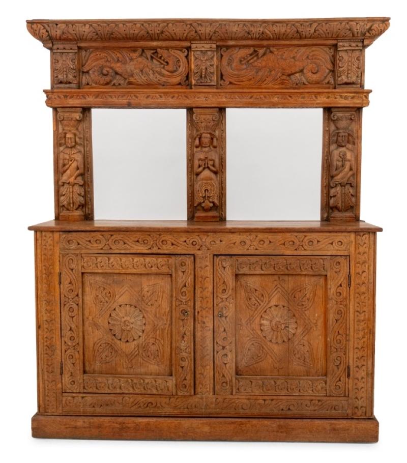 Buffet en chêne sculpté de style Tudor, à deux portes, chacune s'ouvrant pour révéler deux étagères, la partie supérieure décorée de cariatides, ainsi que deux clés en argent doré. 73