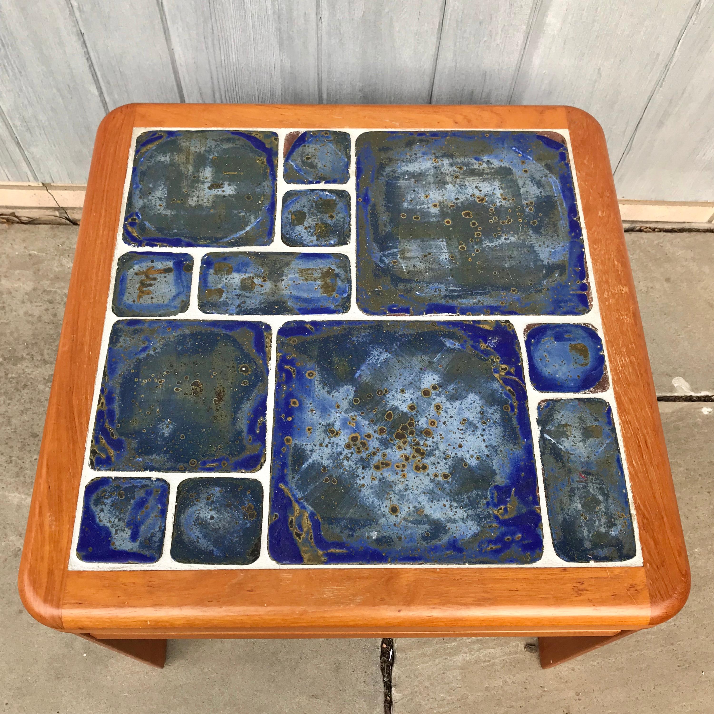 Gorgeous coffee or cocktail table by Tue Poulsen for Haslev of Denmark. Signed By the artist and also with manufacturer’s label. From the 1960s. Beautiful hand painted blue green tiles on square frame. In good condition.