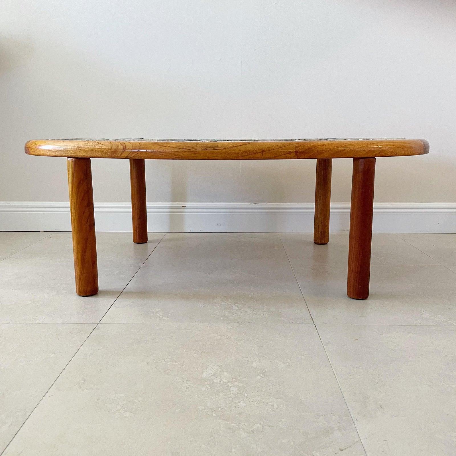 Danish modern handcrafted Tue Poulsen coffee cocktail table for Haslev Møbelsnedkeri A/S, Denmark. The table is an oval shape and crafted in teak with inset with incised, hand painted glazed ceramic tiles in various colors. With signature to tile