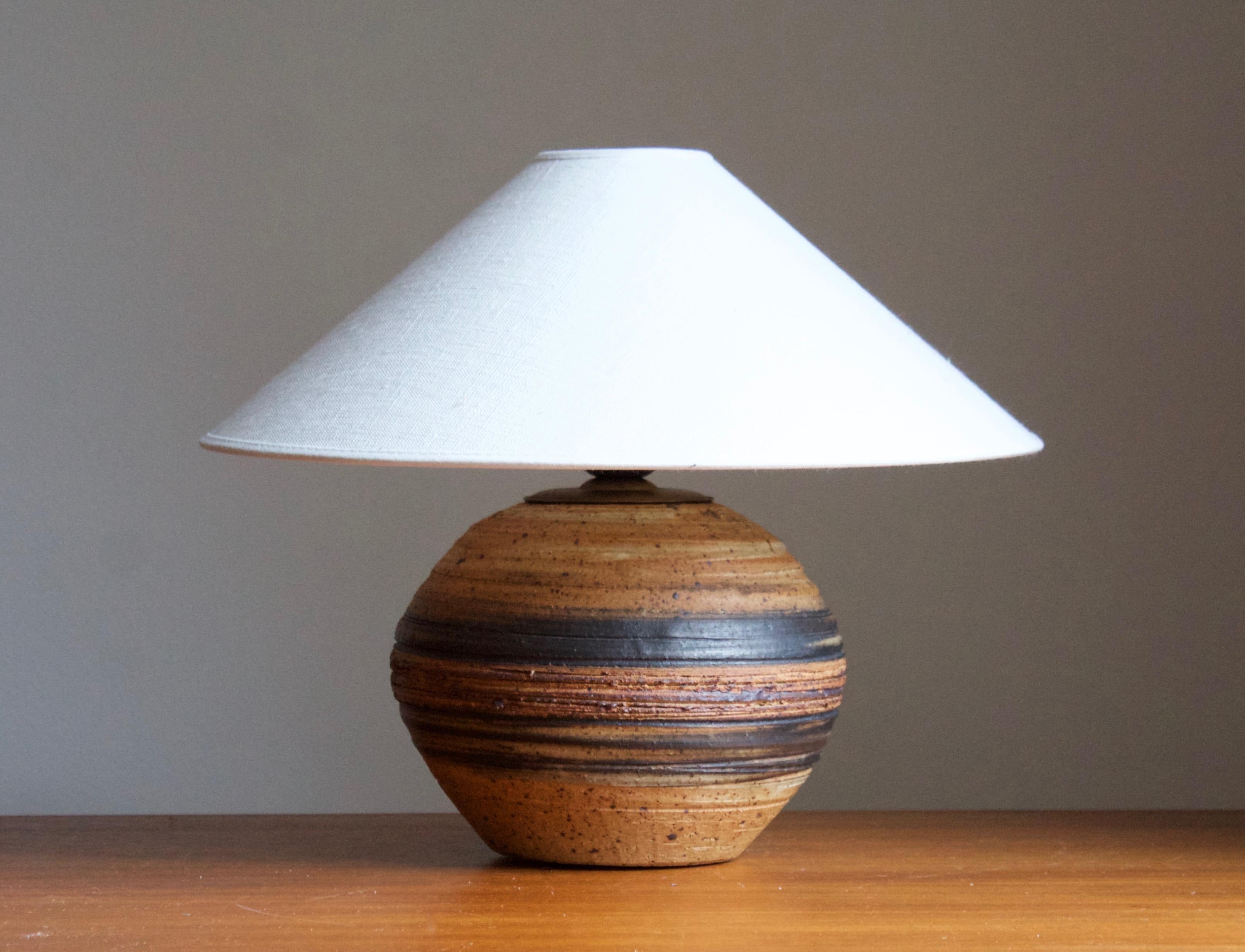 A table lamp. Produced and designed by Tue Poulsen, Denmark, 1960s. Underside of base signed.

Sold without lampshades. Stated dimensions exclude lampshade. Height includes socket.

Glaze features a brown color.

Other designers of the period