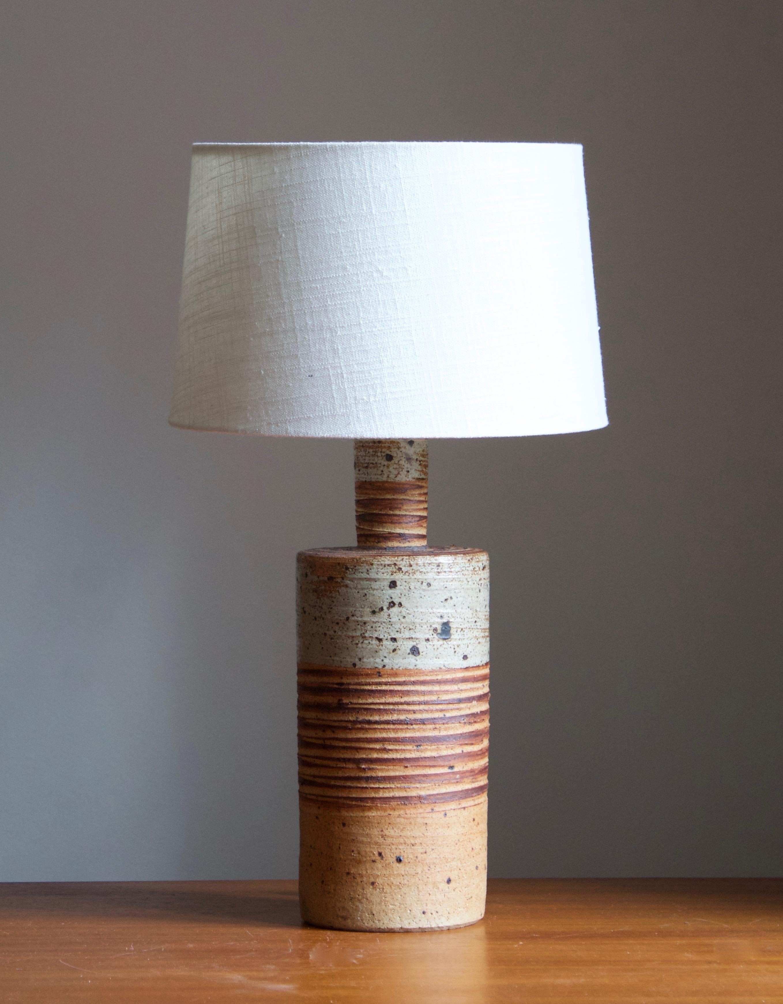 A table lamp. Produced and designed by Tue Poulsen, Denmark, 1960s. Underside of base signed.

Sold without lampshades. Stated dimensions exclude lampshade. Height includes socket.

Glaze features grey-brown colors.

Other designers of the period