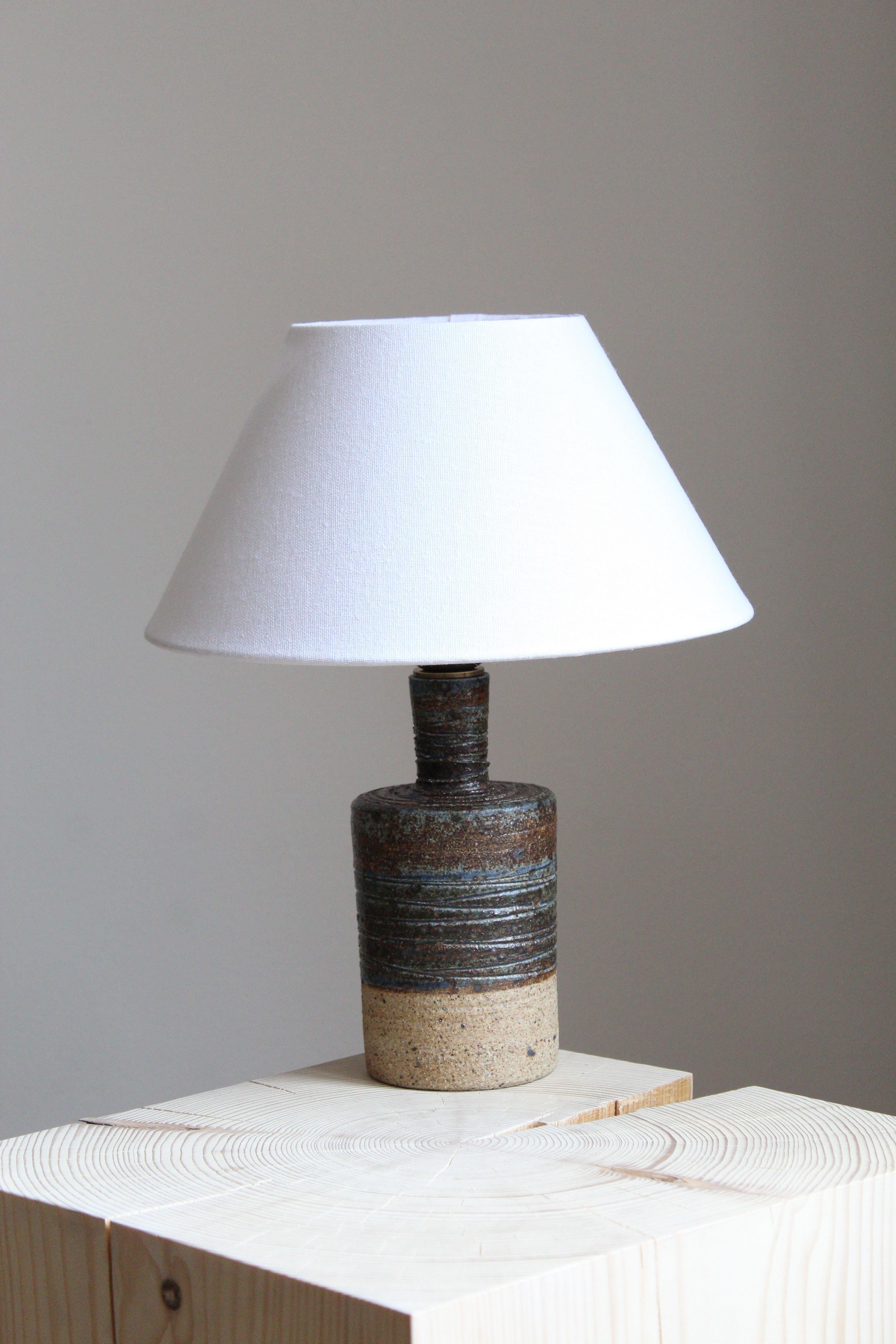 A table lamp. Produced and designed by Tue Poulsen, Denmark, 1960s. Underside of base stamped.

Sold without lampshade. Stated dimensions exclude lampshade. 

Other designers of the period include Axel Salto, Arne Bang, Carl-Harry Stålhane, Lucie