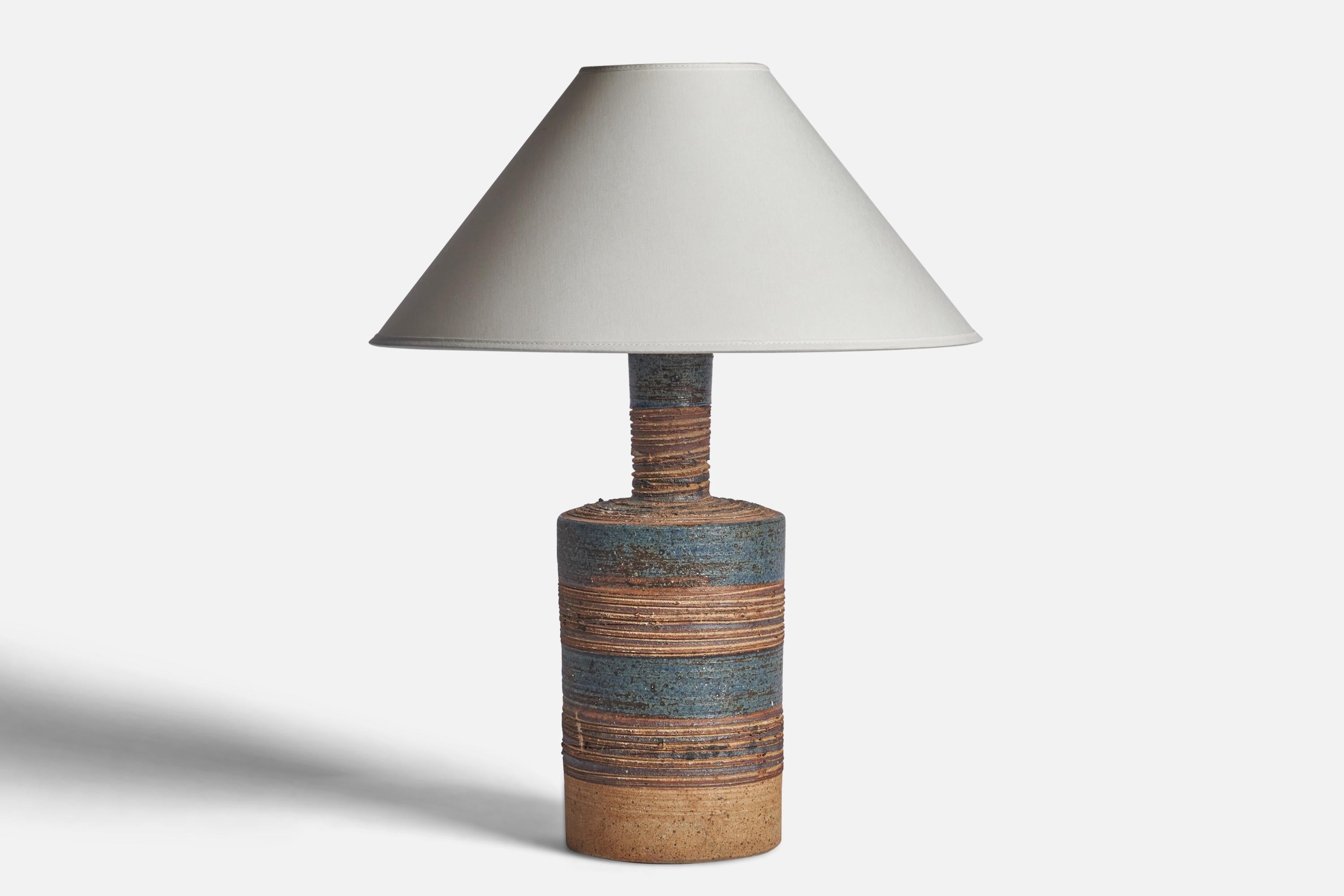A blue and brown-glazed stoneware table lamp designed and produced by Tue Poulsen, Denmark, 1960s.

Dimensions of Lamp (inches): 16.15 H x 5.70” Diameter
Dimensions of Shade (inches): 4.5” Top Diameter x 16” Bottom Diameter x 7.25” H
Dimensions of