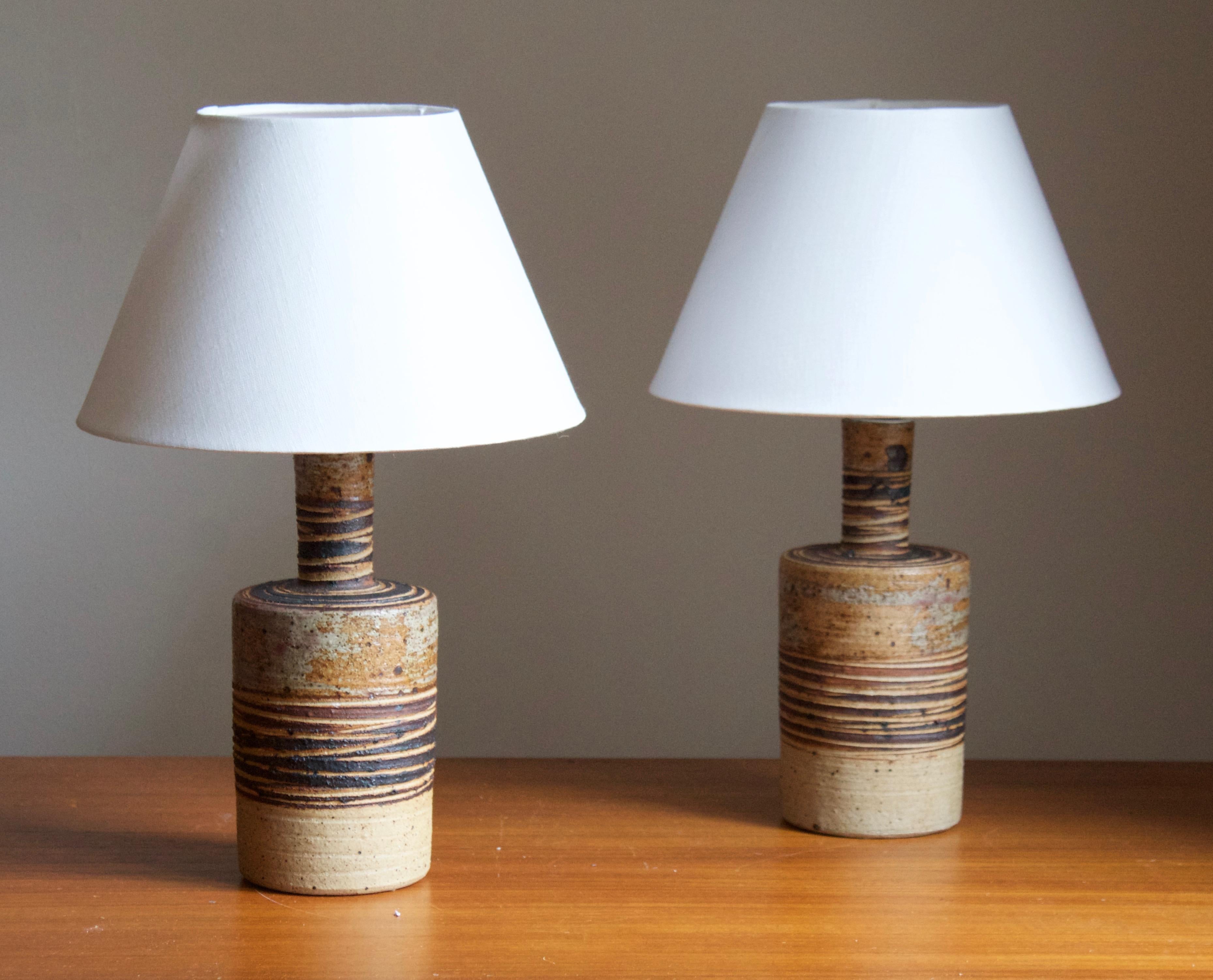 A pair of table lamps. Produced and designed by Tue Poulsen, Denmark, 1960s. Underside of base signed.

Sold without lampshades. Stated dimensions exclude lampshade. Height includes sockets.

Glaze features a brown color.

Other designers of the