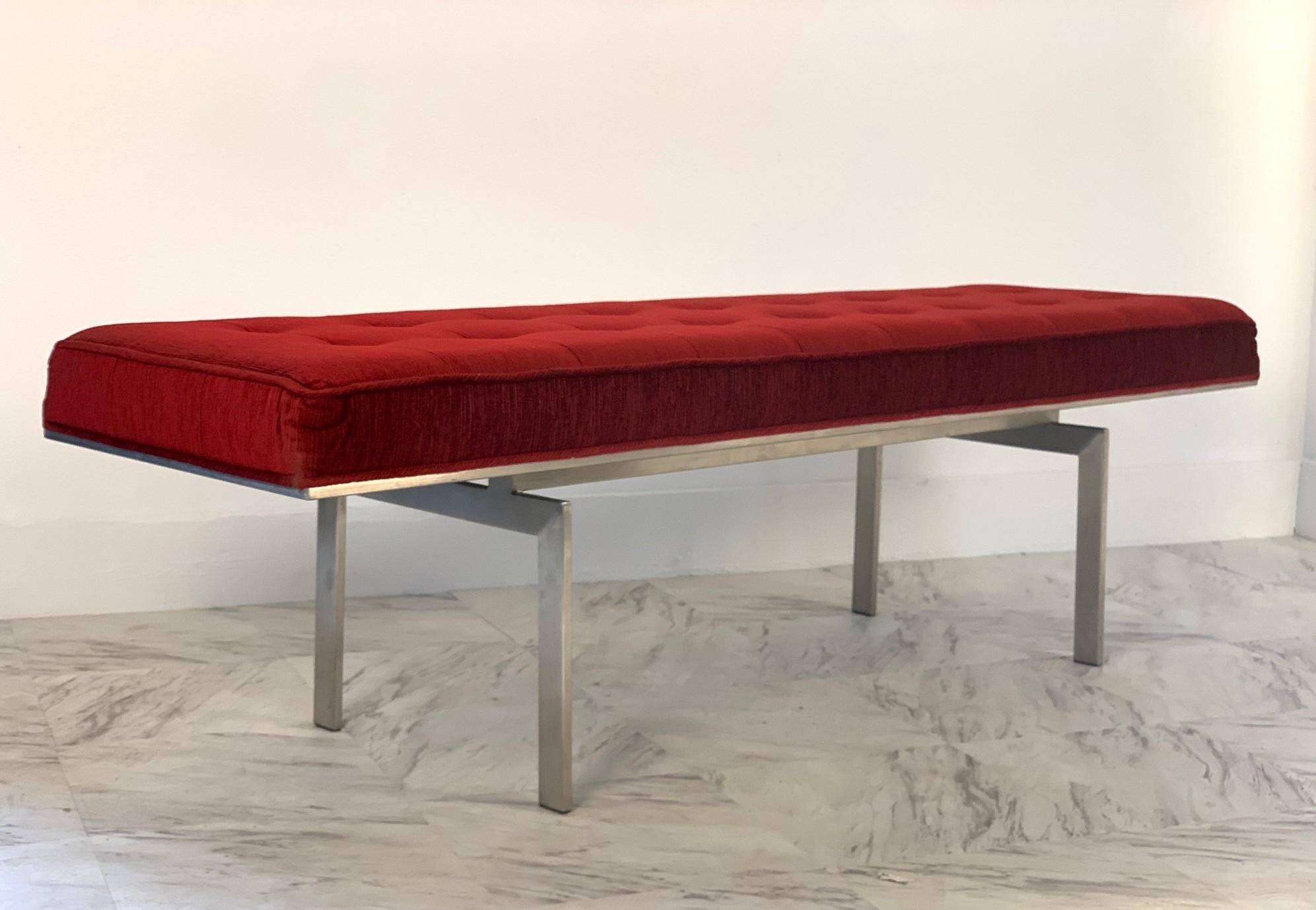 Tufted bench with a brushed steel base in the style of tufted bench style of Poul Kjærholm. Upholstery is of a plum red color. Mid-Century Modern.
