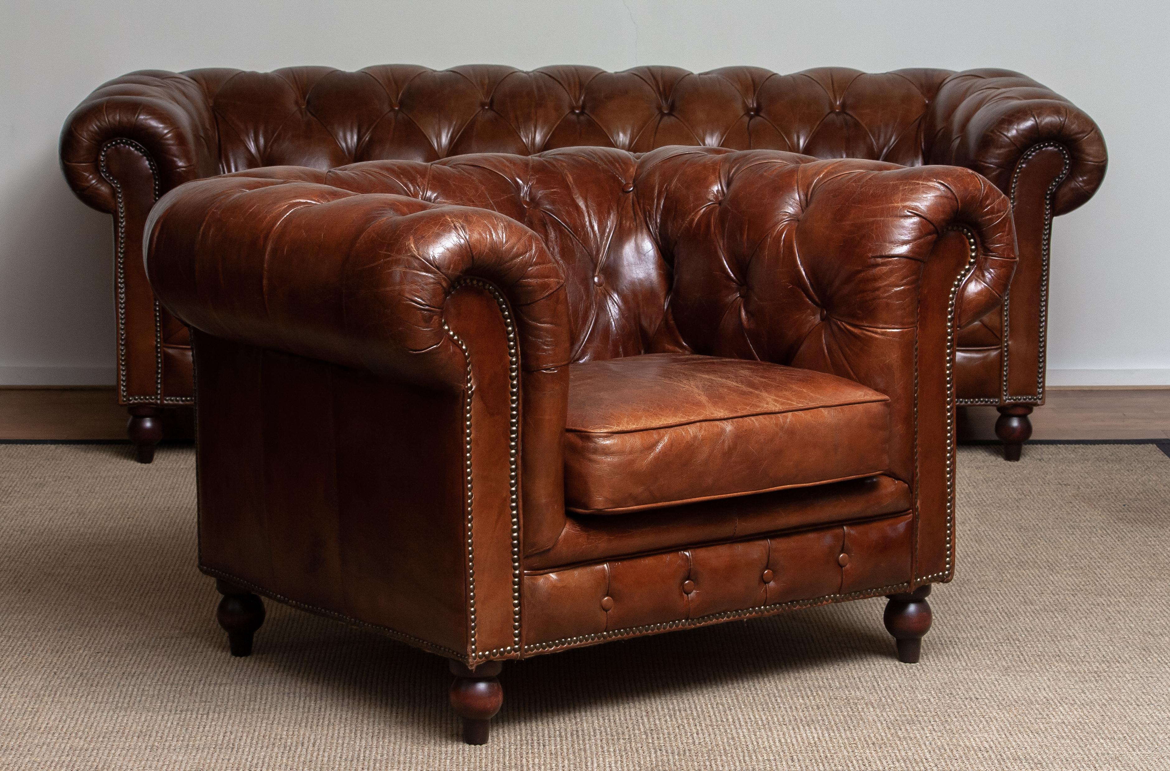 Chesterfield sofa and easy / lounge chair both in chocolate brown leather with a beautiful patina true the years. 
Always been together!
Underneath the seat cushions, filled with feather, is fully sprung therefor the seats are soft and
