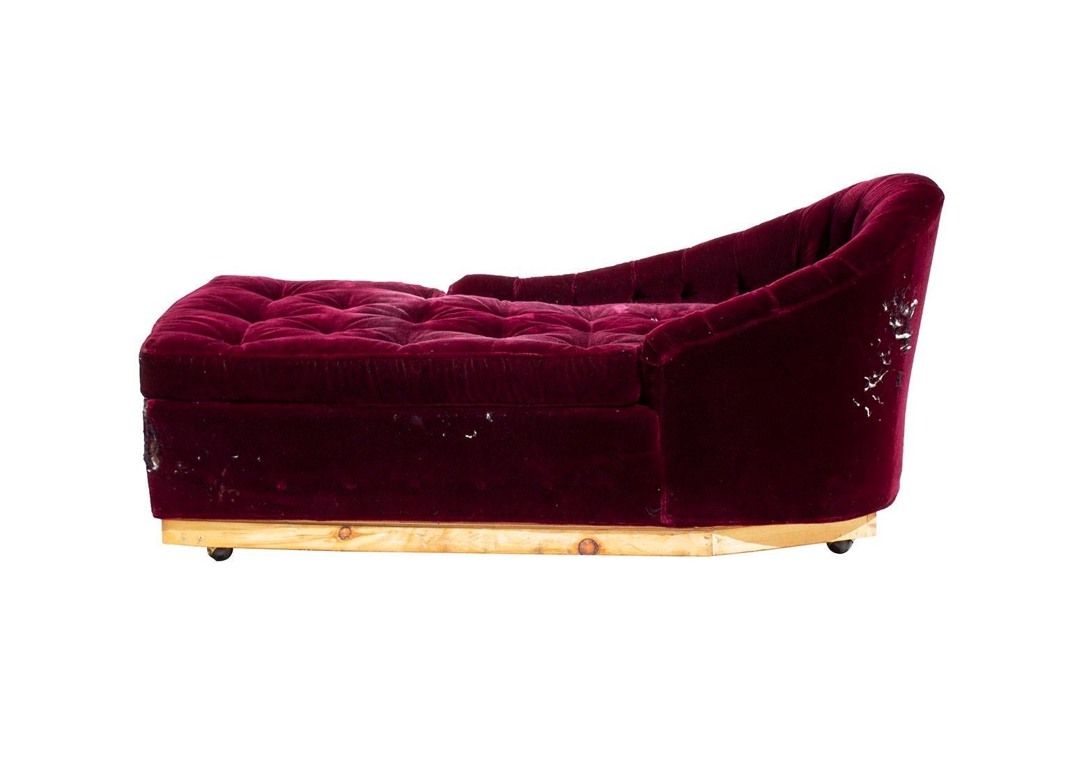 USA, 1940s
Vintage chaise lounge with button tufted upholstery in heavily worn and torn burgundy velvet. Gorgeous uneven arms offer entry on the left side of the chaise. This has what appears to be a non original plinth style base. I removed faux