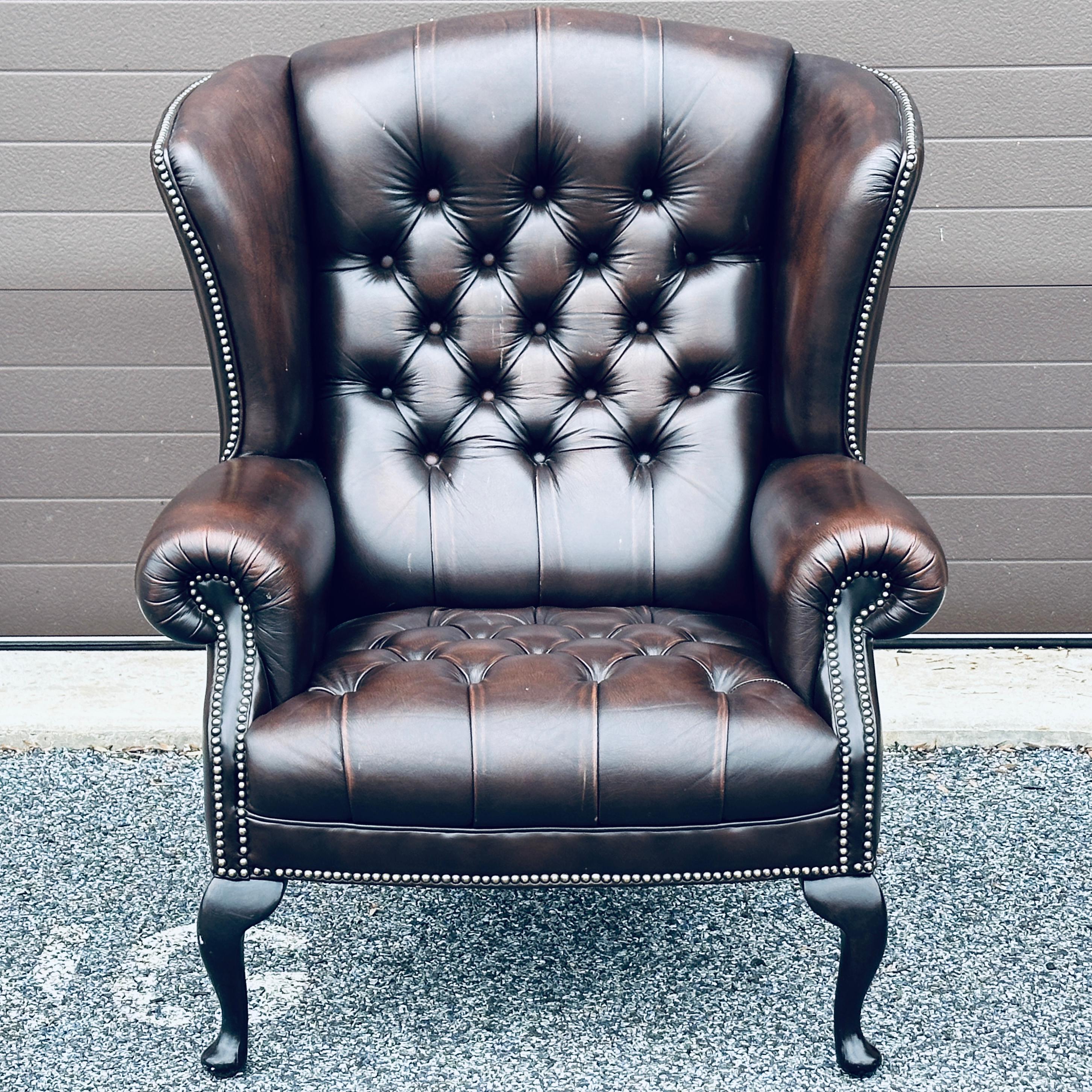 Classic tufted English dark brown leather wing chair. Made in England by notable maker Pendragon.