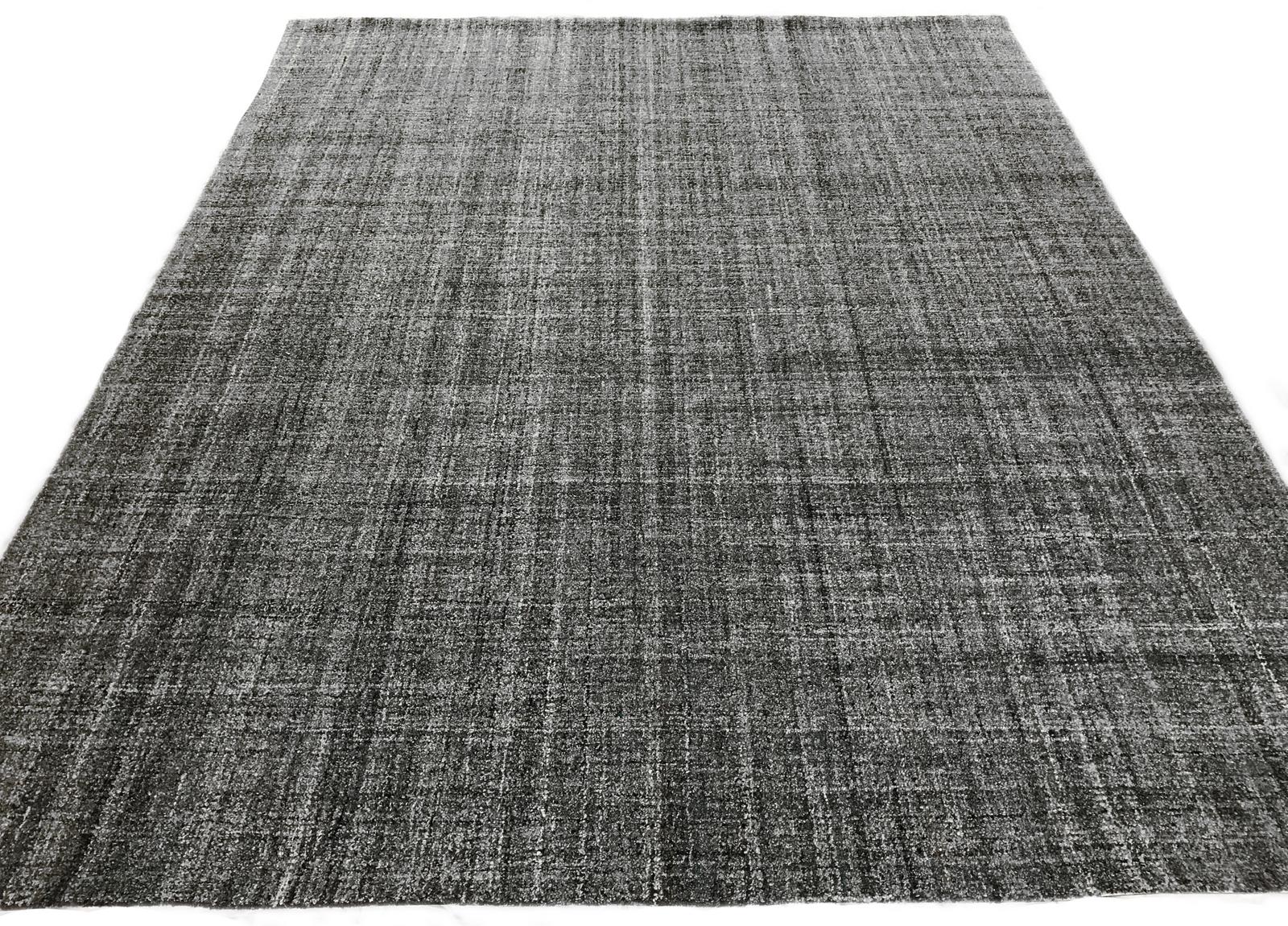 Create a contemporary foundation with this tufted gray Indian wool area rug. Dark gold and turquoise details bring an added element of color without compromising versatility.