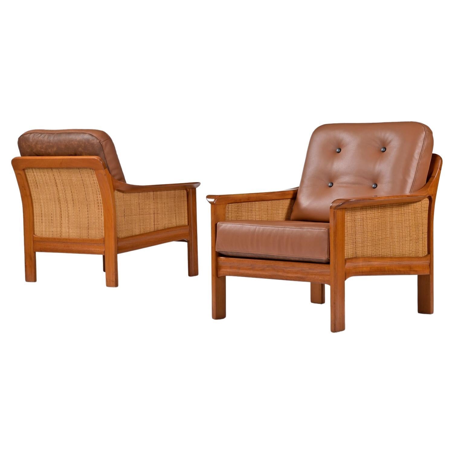 Although not marked by the maker, these exceptional, vintage (late 1970s / early 1980s) solid teak armchairs have a distinctive Danish modern design but may actually be Canadian. The chairs feature 3-panels of woven reed cane that cover the sides