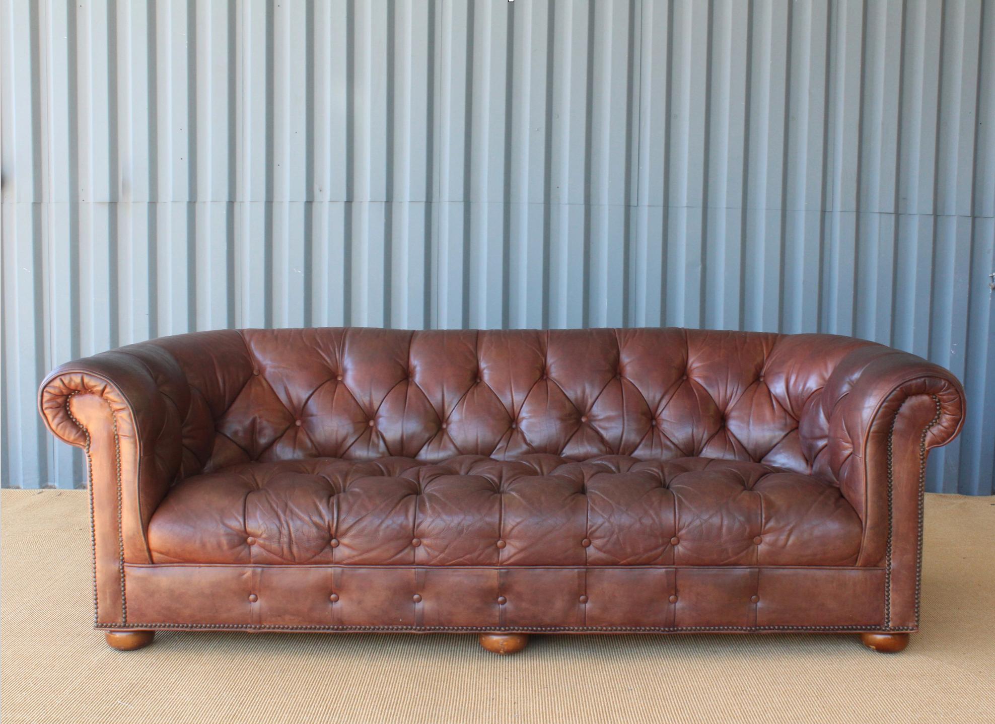 Beautiful tufted chesterfield sofa in a beautifully aged leather with the perfect amount of patina. This sofa has been recently reconditioned yet still shows age appropriate wear. Leather shows checking in some areas.