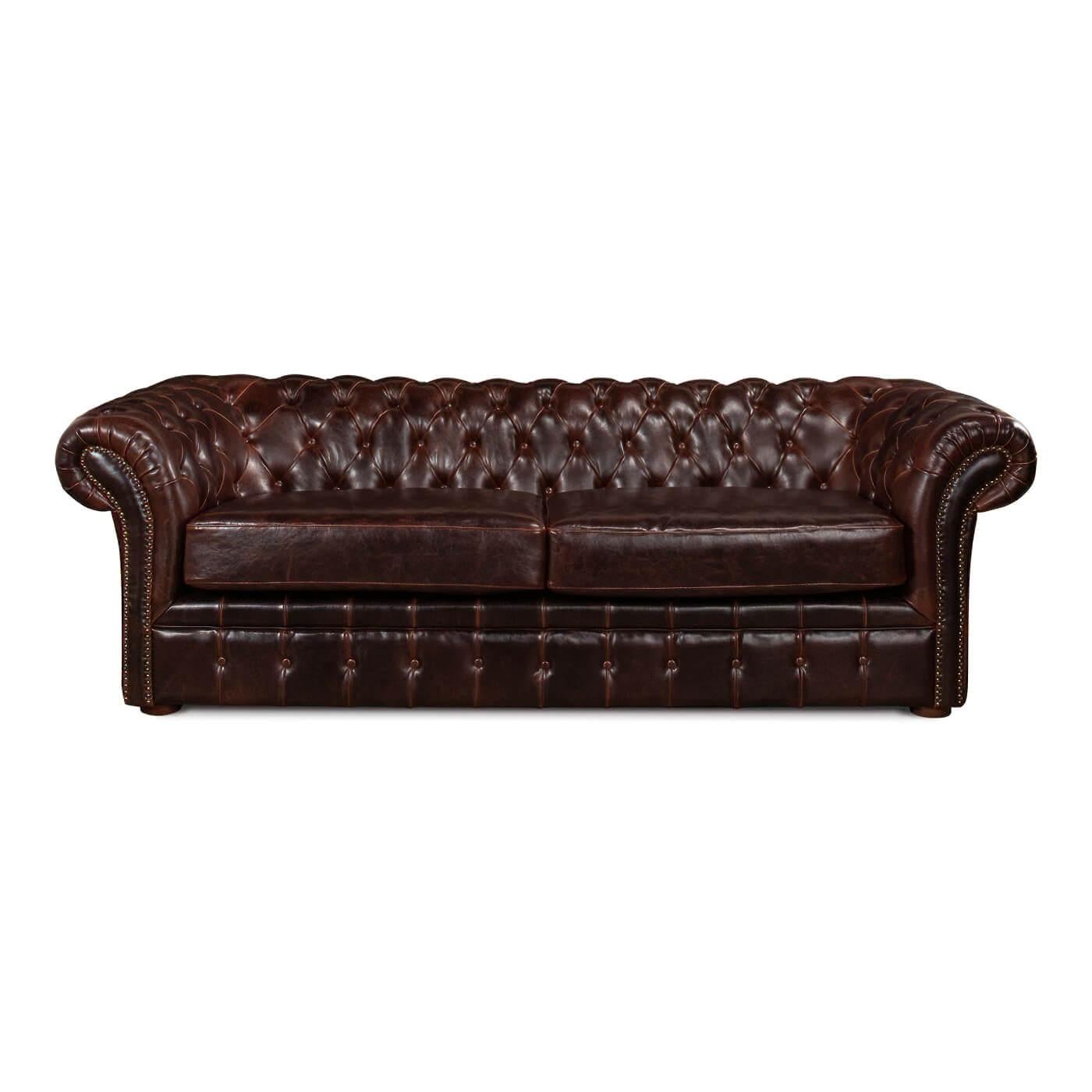 Canapé Chesterfield en cuir tufté, recouvert d'un riche cuir marron traditionnel. Une version du design anglais traditionnel du 19ème siècle avec des accoudoirs et un dossier roulés et touffus et une assise à coussin fendu.

Dimensions : 91