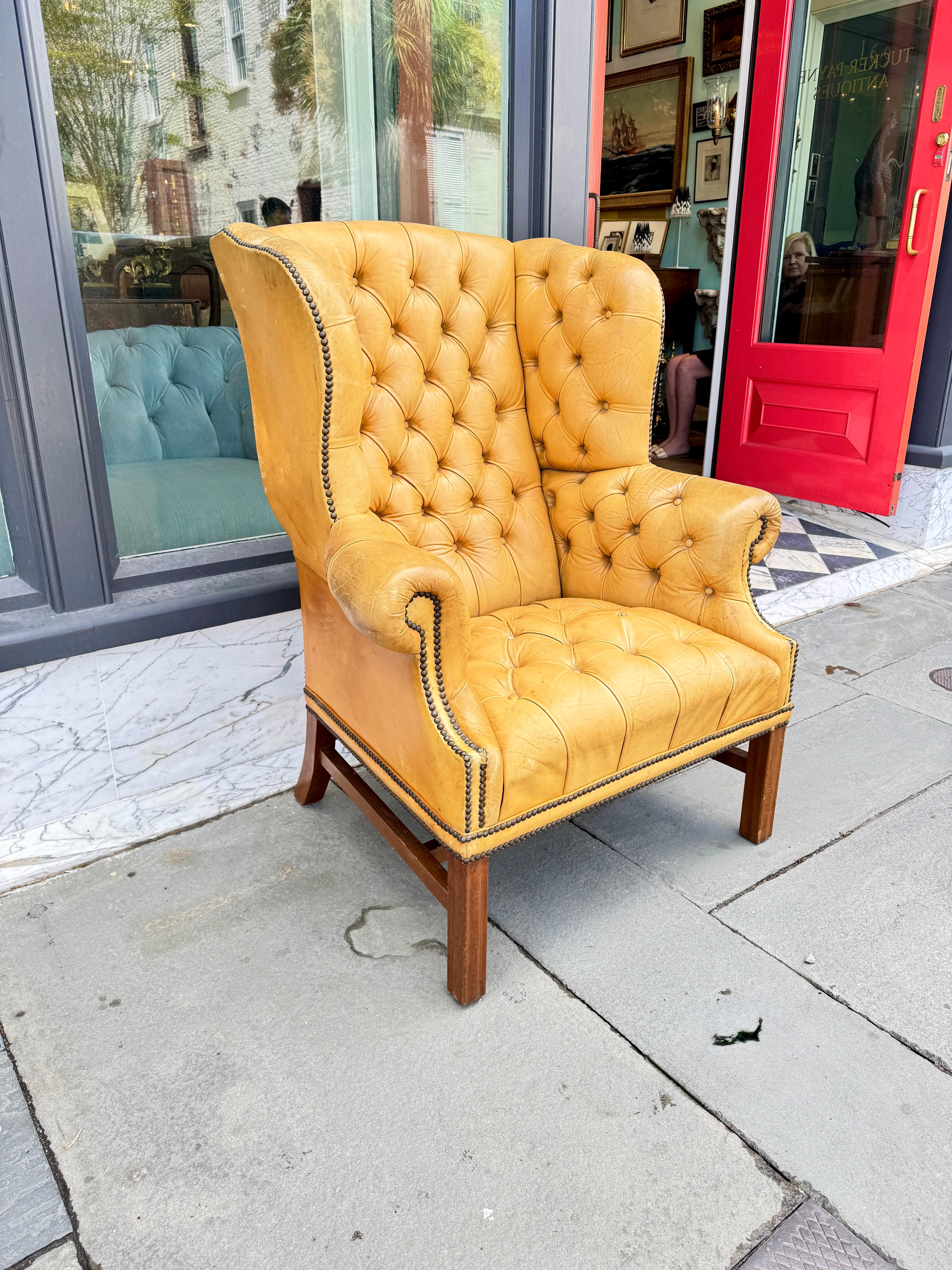 Tufted leather wingback chairs with mahogany legs. Leather has a warm buttery color. 